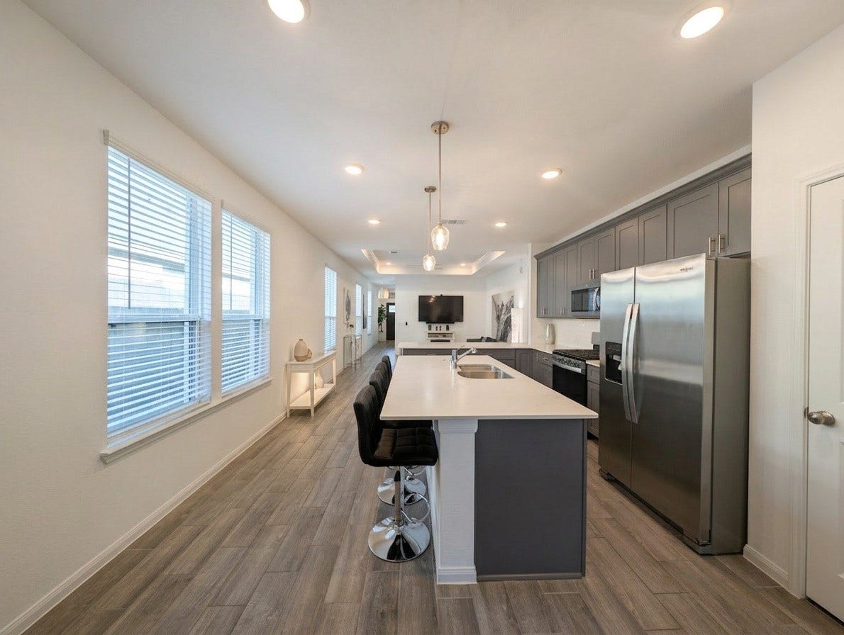 18122 Sonresa Way, Tomball, TX 77377 Kitchen island and breakfast bar setup with modern pendant fixtures and under-cabinet lighting.