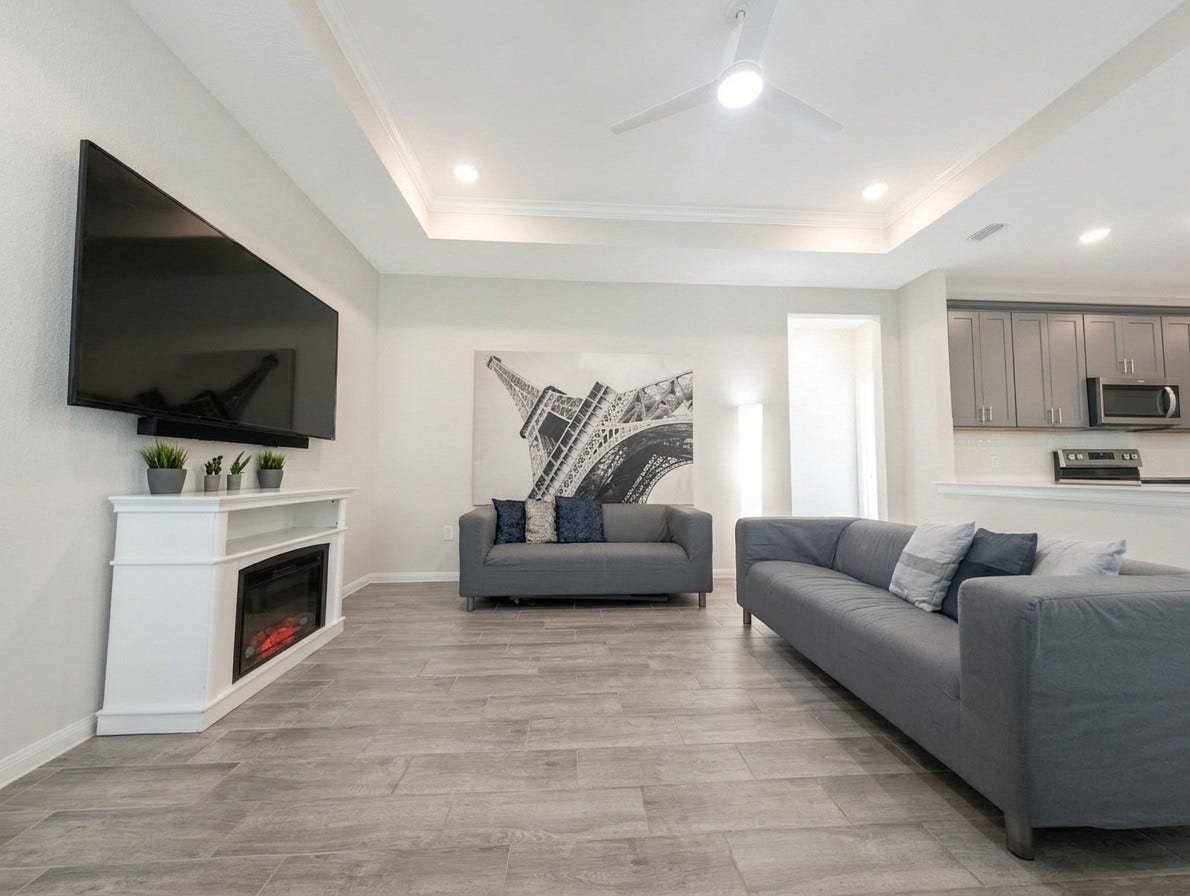 18122 Sonresa Way, Tomball, TX 77377 Spacious living room featuring an entertainment wall, built-in electric fireplace, and large windows bringing in natural light.
