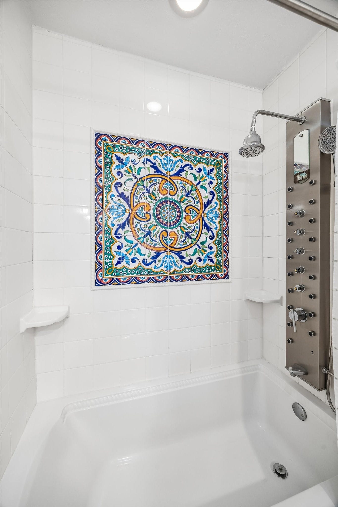 Luxurious shower features a striking decorative tile centerpiece and a modern multi-jet shower panel, creating a spa-like experience.