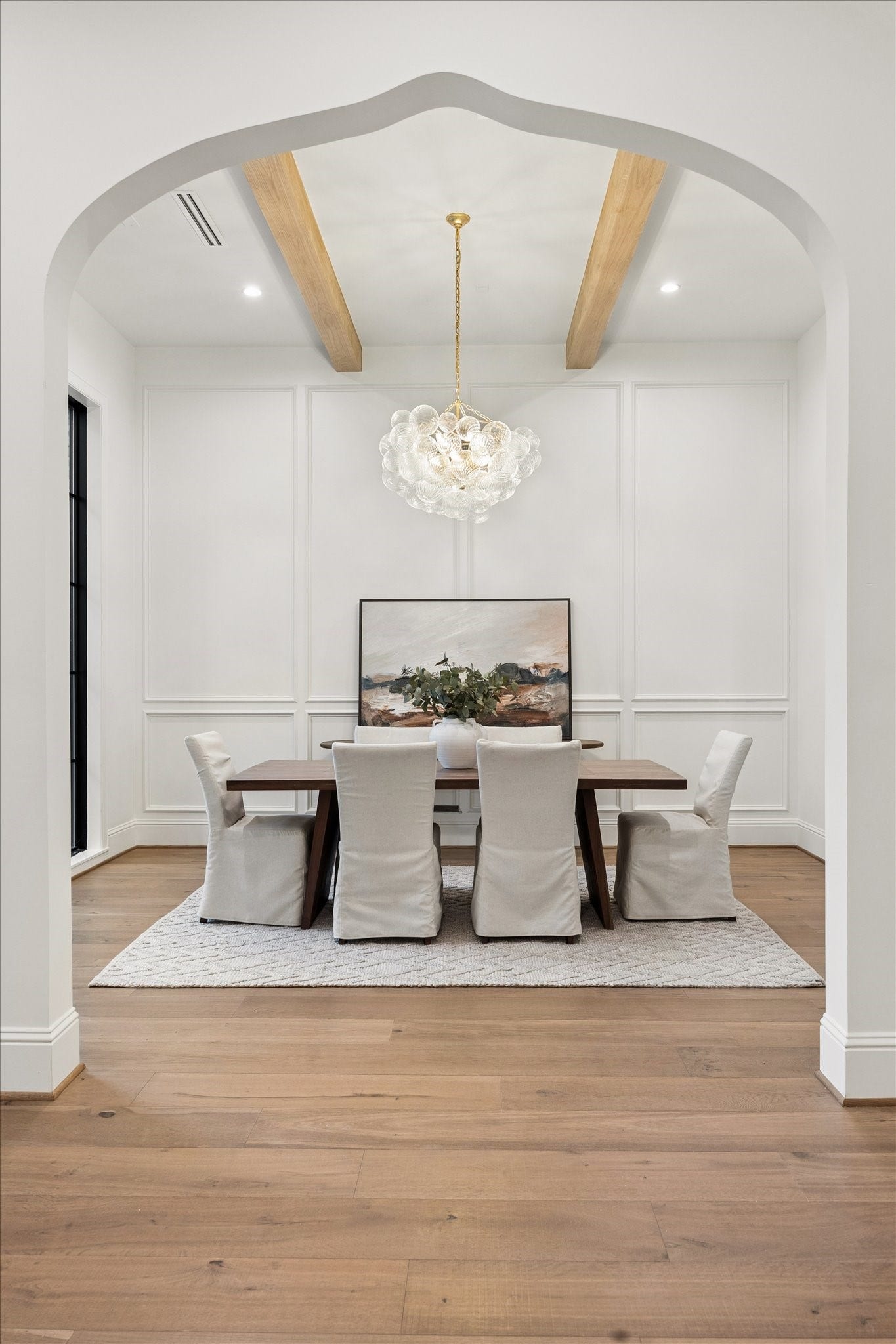 7719 Bryonwood Drive, Houston, TX 77055 A sculpted arch and exposed wood beams frame the formal dining room.