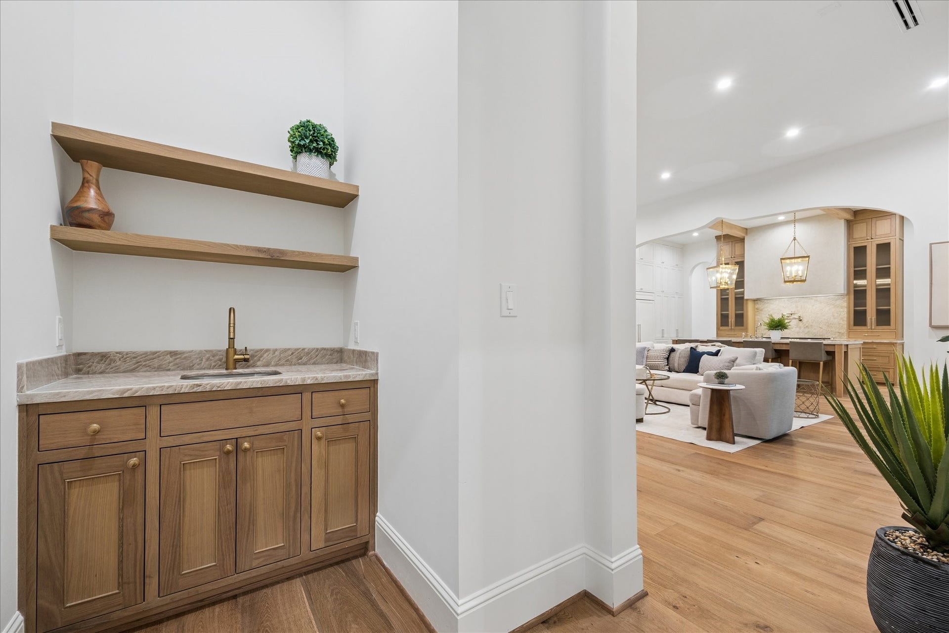 7719 Bryonwood Drive, Houston, TX 77055 A wet bar with floating shelves and oak cabinetry sits steps from the family room.