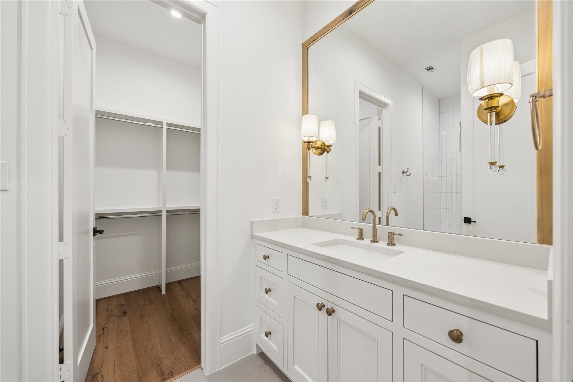 7719 Bryonwood Drive, Houston, TX 77055 A gold-framed mirror and brass sconces accent this en-suite bath.