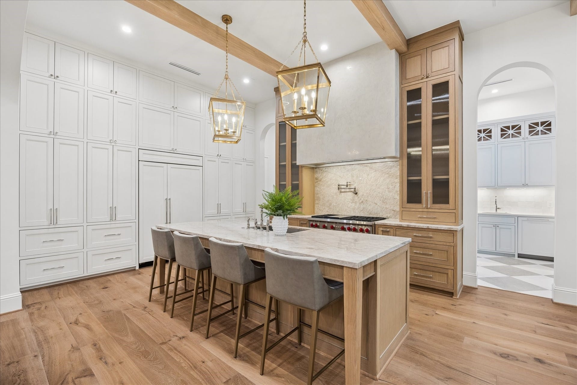 7719 Bryonwood Drive, Houston, TX 77055 The chef's kitchen pairs Sub-Zero and Wolf appliances with ceiling-height cabinetry under exposed beams.