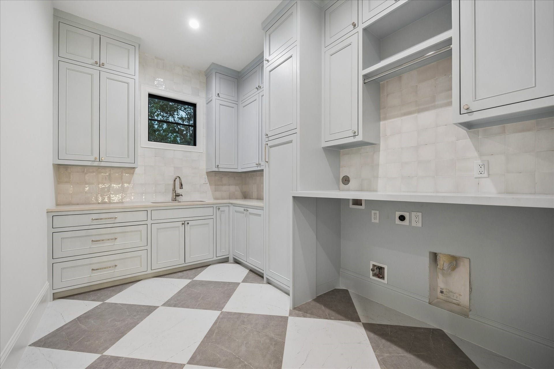 7719 Bryonwood Drive, Houston, TX 77055 The utility room has a sink, ample cabinetry, a folding counter, and checkerboard tile.