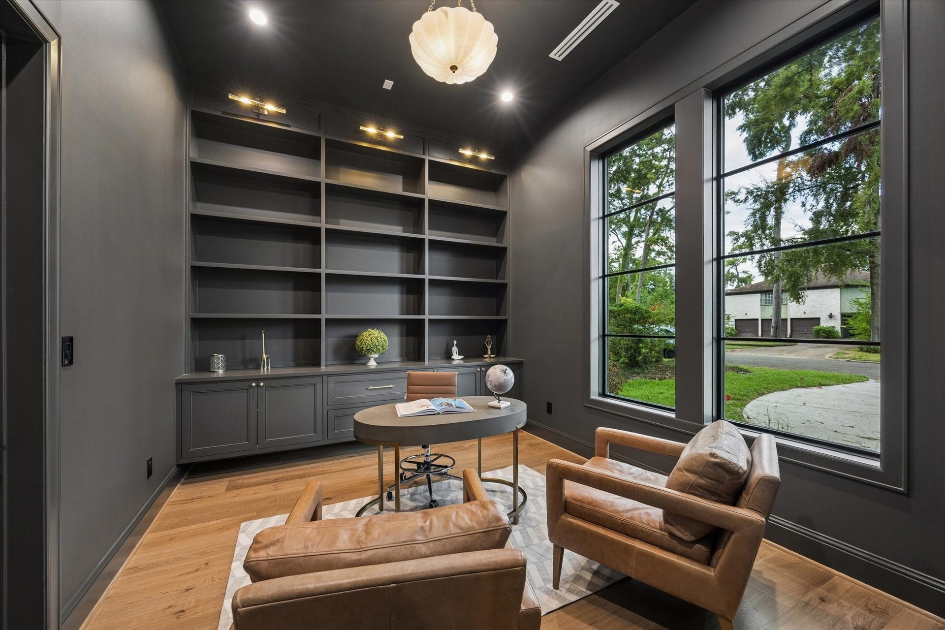 7719 Bryonwood Drive, Houston, TX 77055 The front study is wrapped in dark built-in shelving, with oversized windows facing the front lawn.