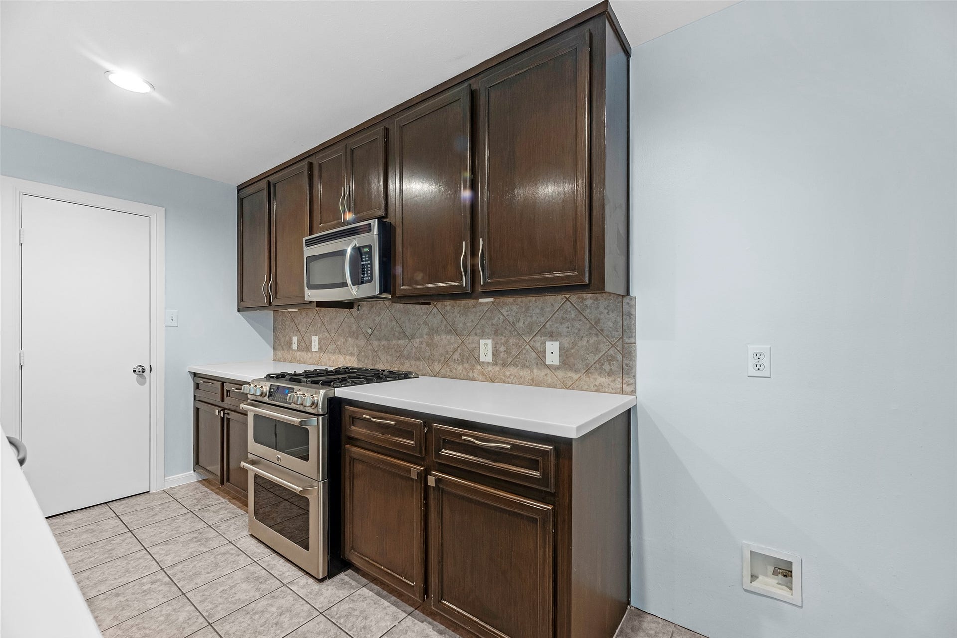 1712 Bevis Street, Houston, TX 77008 The spacious kitchen features rich brown cabinetry, granite countertops, stainless steel appliances, a gas cooktop, and double ovensperfect for everyday cooking and entertaining.