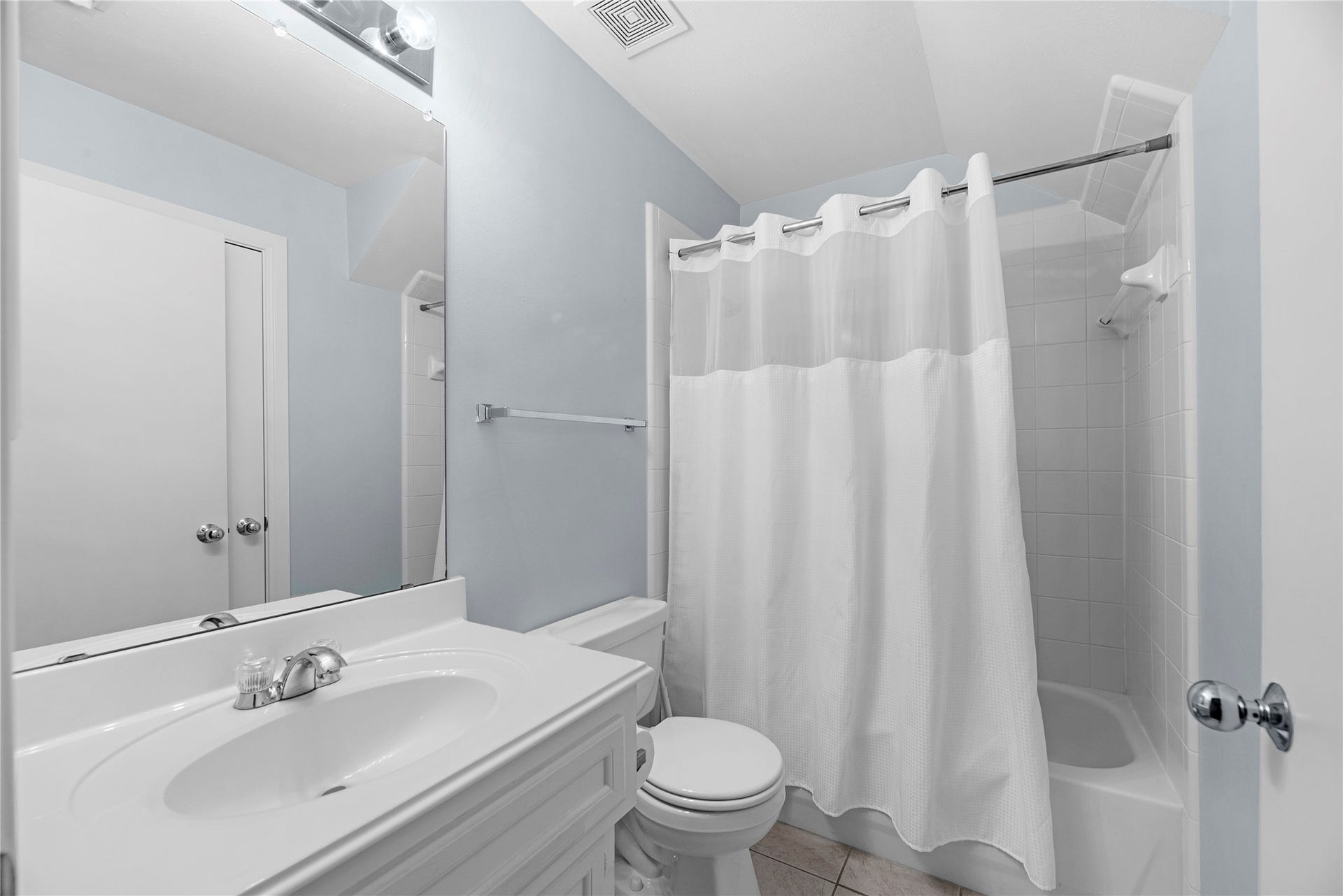 1712 Bevis Street, Houston, TX 77008 The en suite guest bathroom features a clean, functional design with white cabinetry, a single-sink vanity, tile flooring, and a tub/shower combination. Conveniently connected to the first-floor guest suite, it provides a private full bath for guests.
