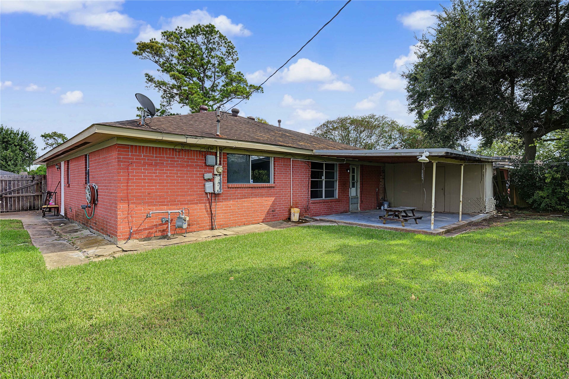 7510 Baneway Drive, Houston, TX 77072 Spacious backyard view featuring a covered patio, mature shade tree, and plenty of green space.