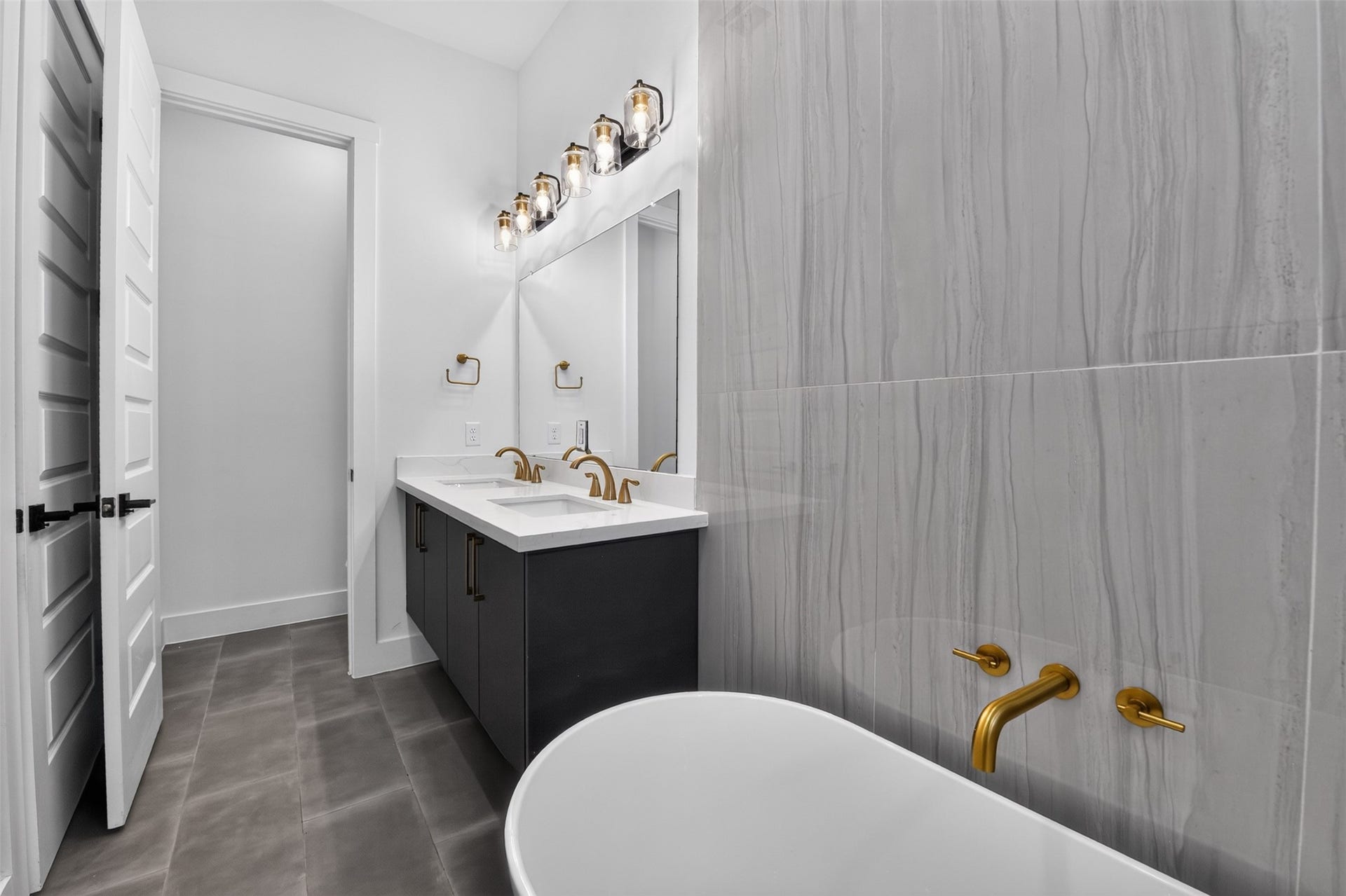 2911 Wichita Street, Houston, TX 77004 This sophisticated primary bath features dual vanities, statement brass fixtures, and a beautifully designed space to unwind and refresh.