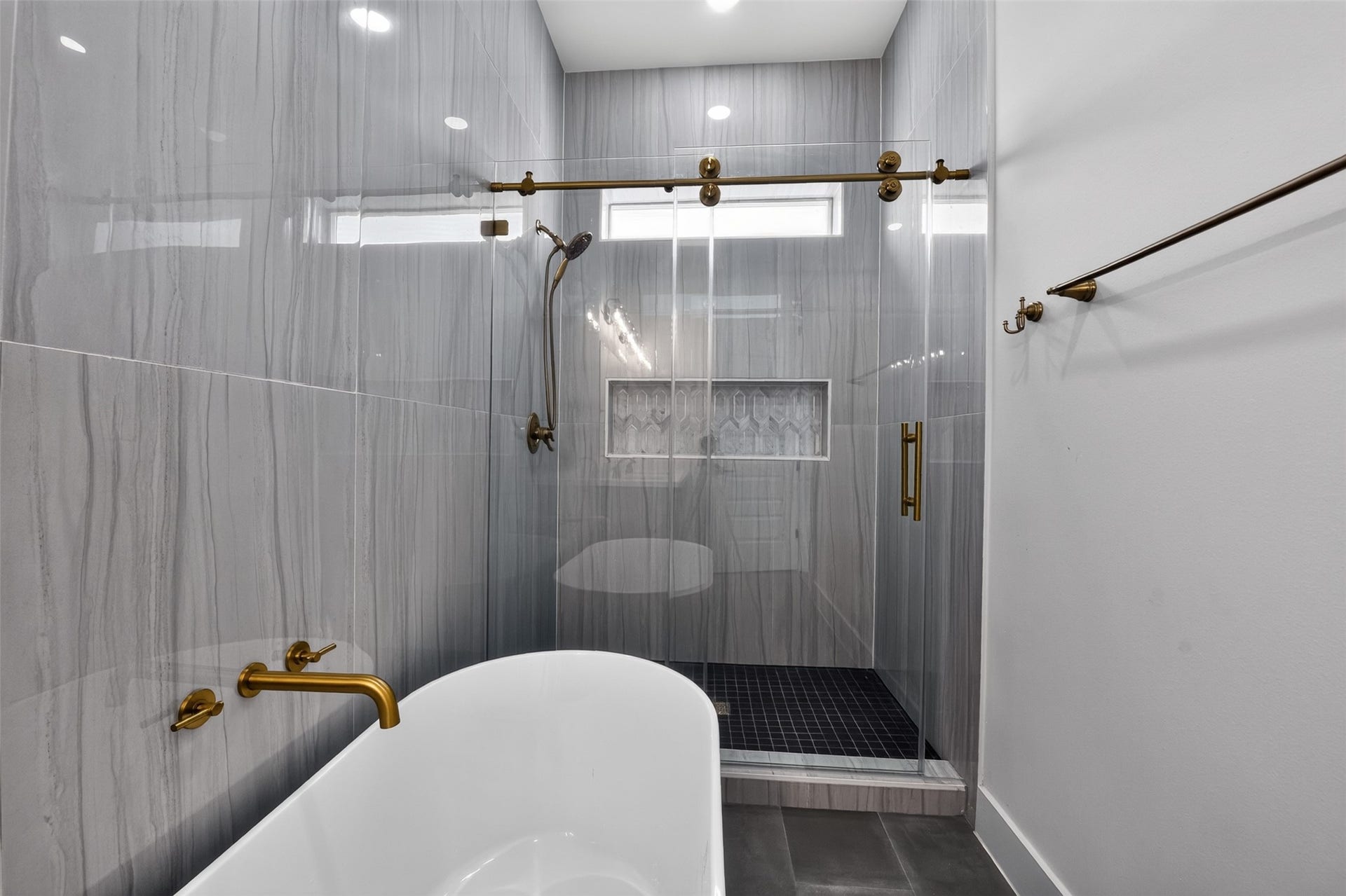 2911 Wichita Street, Houston, TX 77004 Every detail invites relaxation in this beautifully appointed primary bath with floor to ceiling tiles, where an expansive shower, luxurious soaking tub, and timeless design create a true spa-like escape.