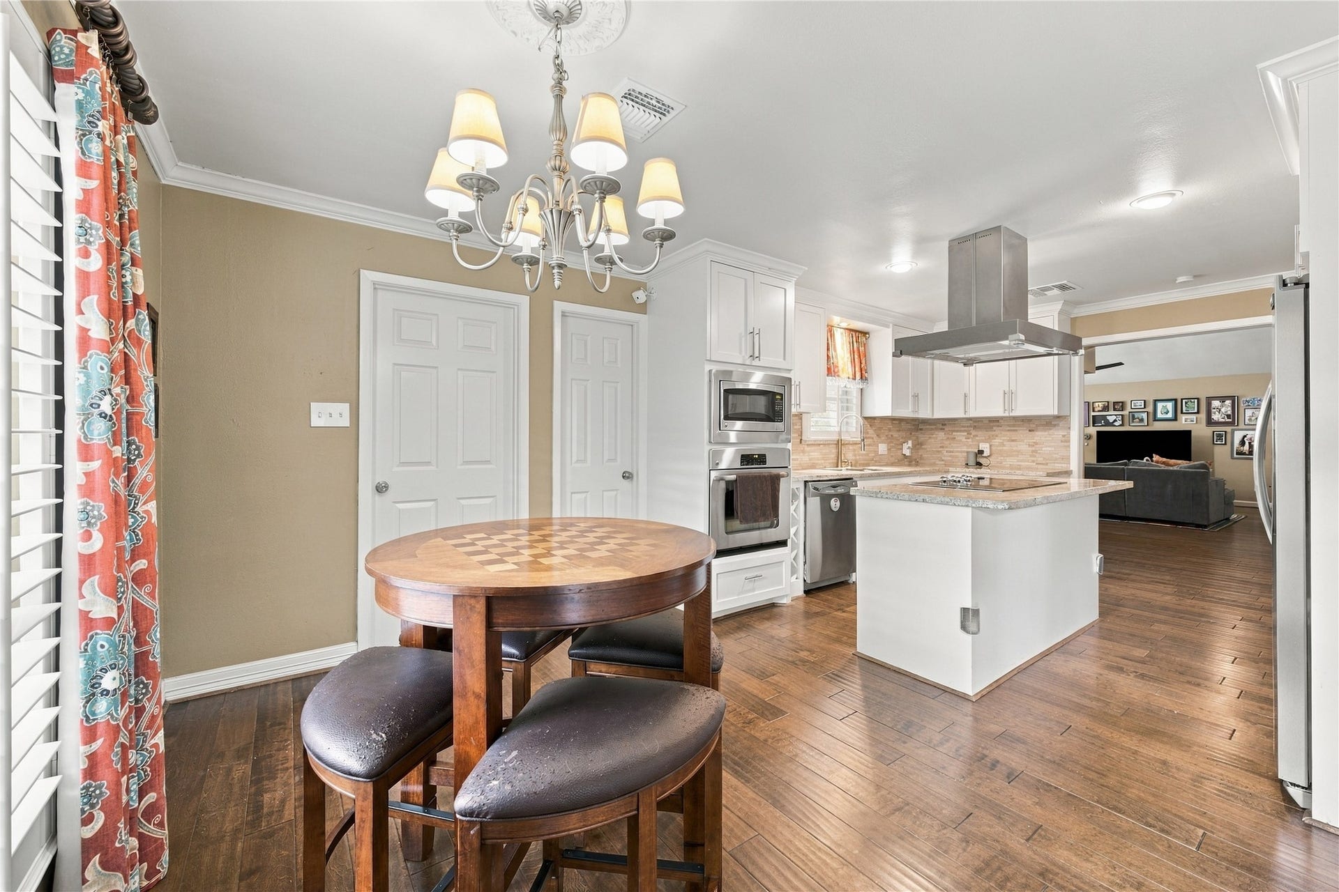 3211 Chris Drive, Houston, TX 77063 Charming breakfast nook with chandelier, crown molding & white French doors opening to a private side patio while the opening adjacent the French doors leads into to the formal dining room.