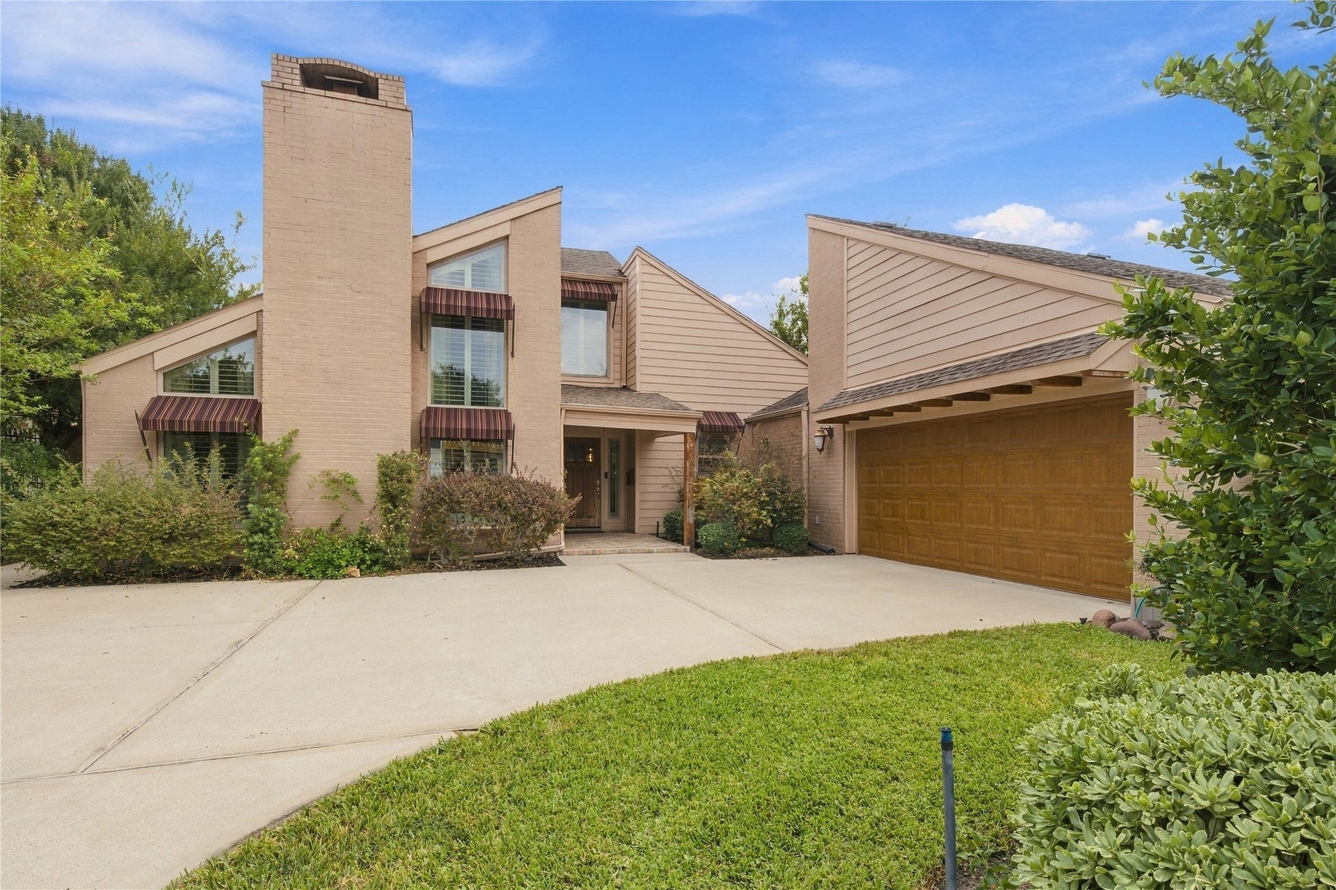 3211 Chris Drive, Houston, TX 77063 Curved double-wide driveway leads to the attached two-car garage, offering plenty of extra parking for residents & guests. Exposed rafter tails under the eave add a charming architectural detail.