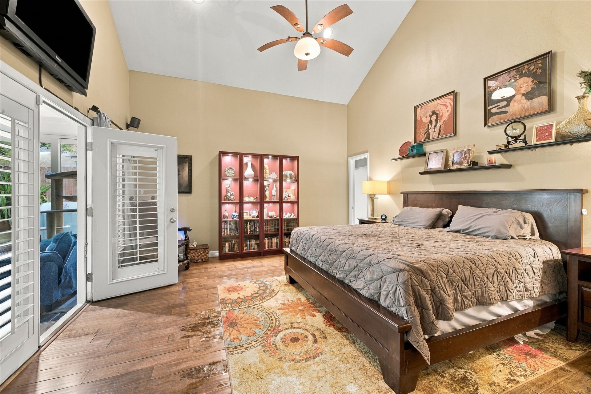 3211 Chris Drive, Houston, TX 77063 Spacious primary bedroom features a dramatic vaulted ceiling, and rich wood floors, offering a private retreat. A doorway on the back wall leads to the en-suite bath & walk-in closet, the perfect space to relax after a long day.
