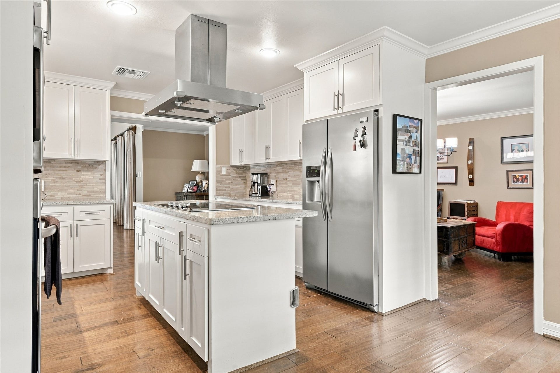 3211 Chris Drive, Houston, TX 77063 Stainless steel side-by-side refrigerator is framed by shaker style cabinetry with storage above, and the island adds additional storage.