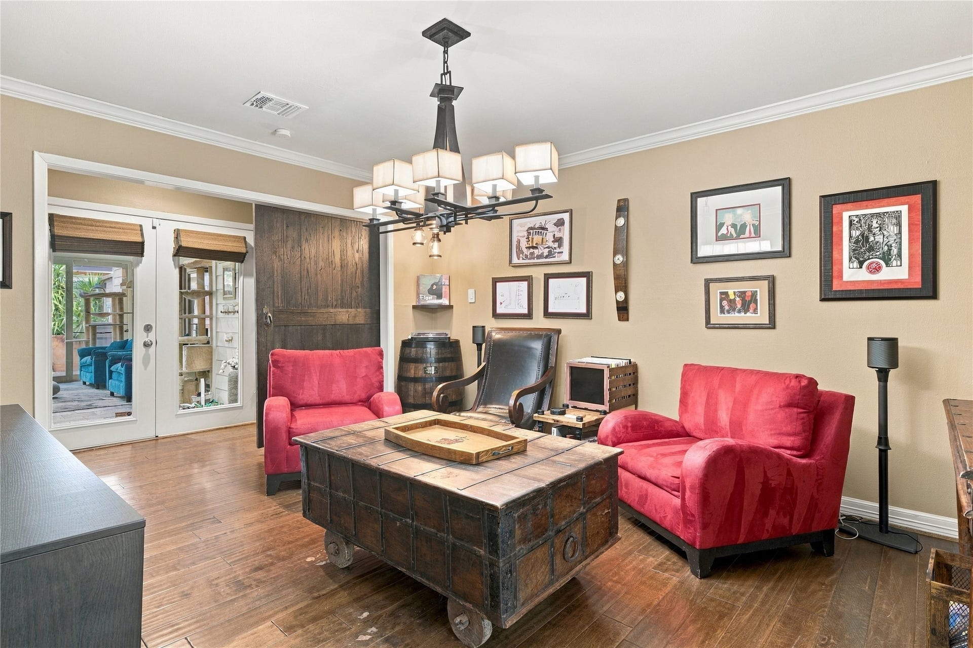 3211 Chris Drive, Houston, TX 77063 This warm and inviting formal dining room, currently used as a lounge/den, features a sliding wood barn door, crown molding & a modern iron chandelier. Perfect for family gatherings or an additional seating space.