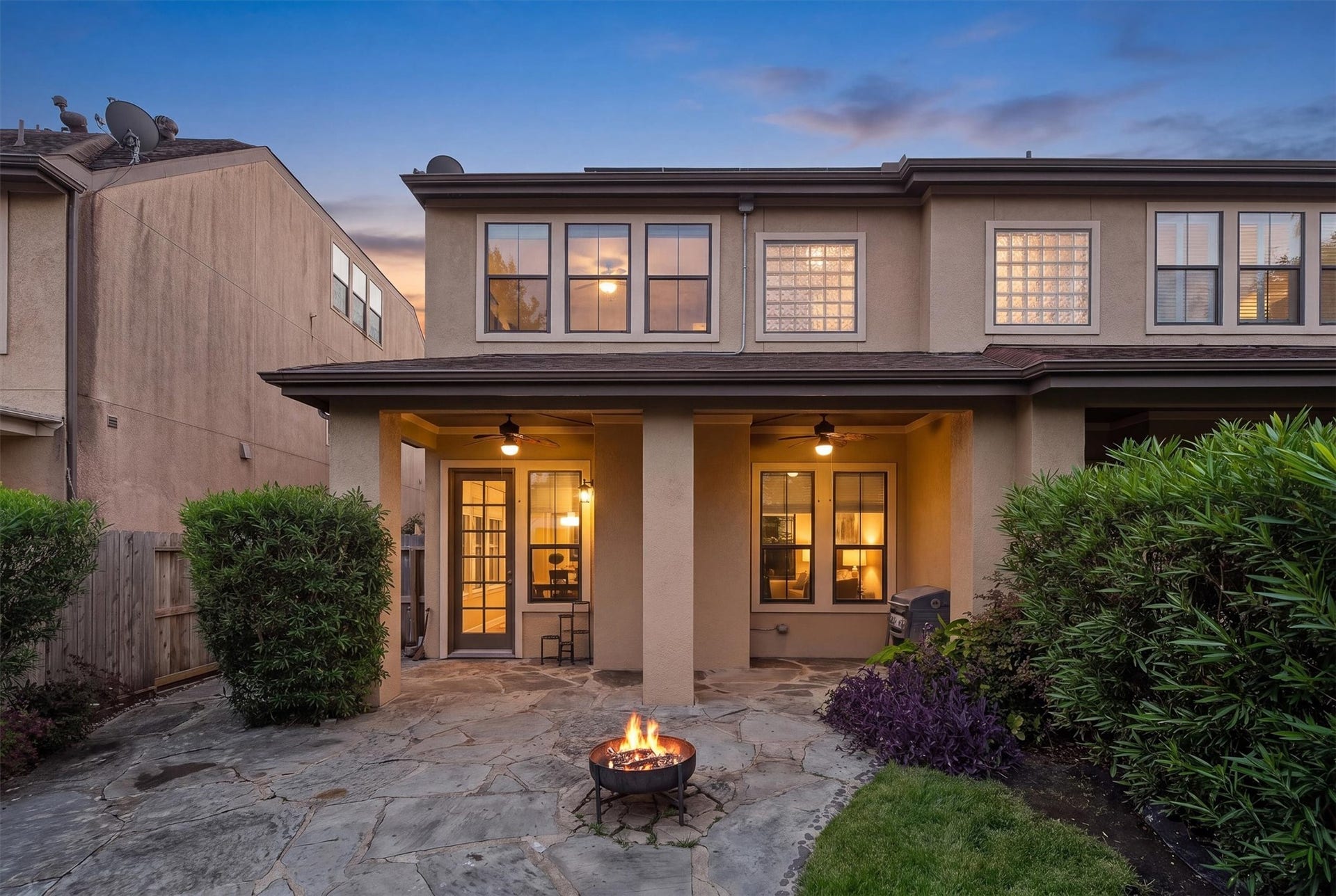 2919 Royal Oaks Crest, Houston, TX 77082 Charming two-story home with a cozy backyard patio, featuring a fire pit and lush landscaping, perfect for evening relaxation.