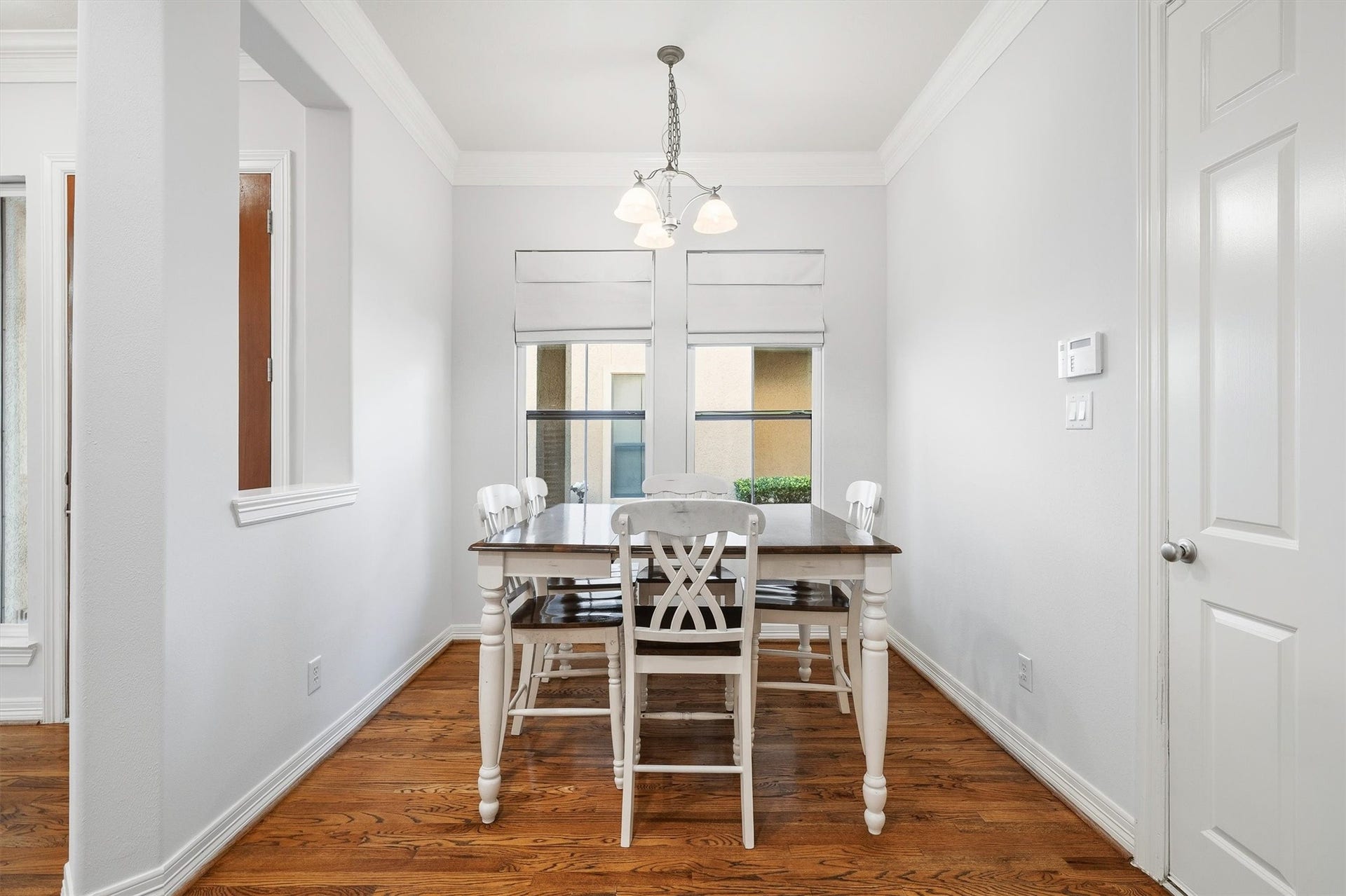 2919 Royal Oaks Crest, Houston, TX 77082 Charming breakfast area with elegant hardwood floors, featuring a cozy table set under a stylish light fixture and natural light from two large windows.
