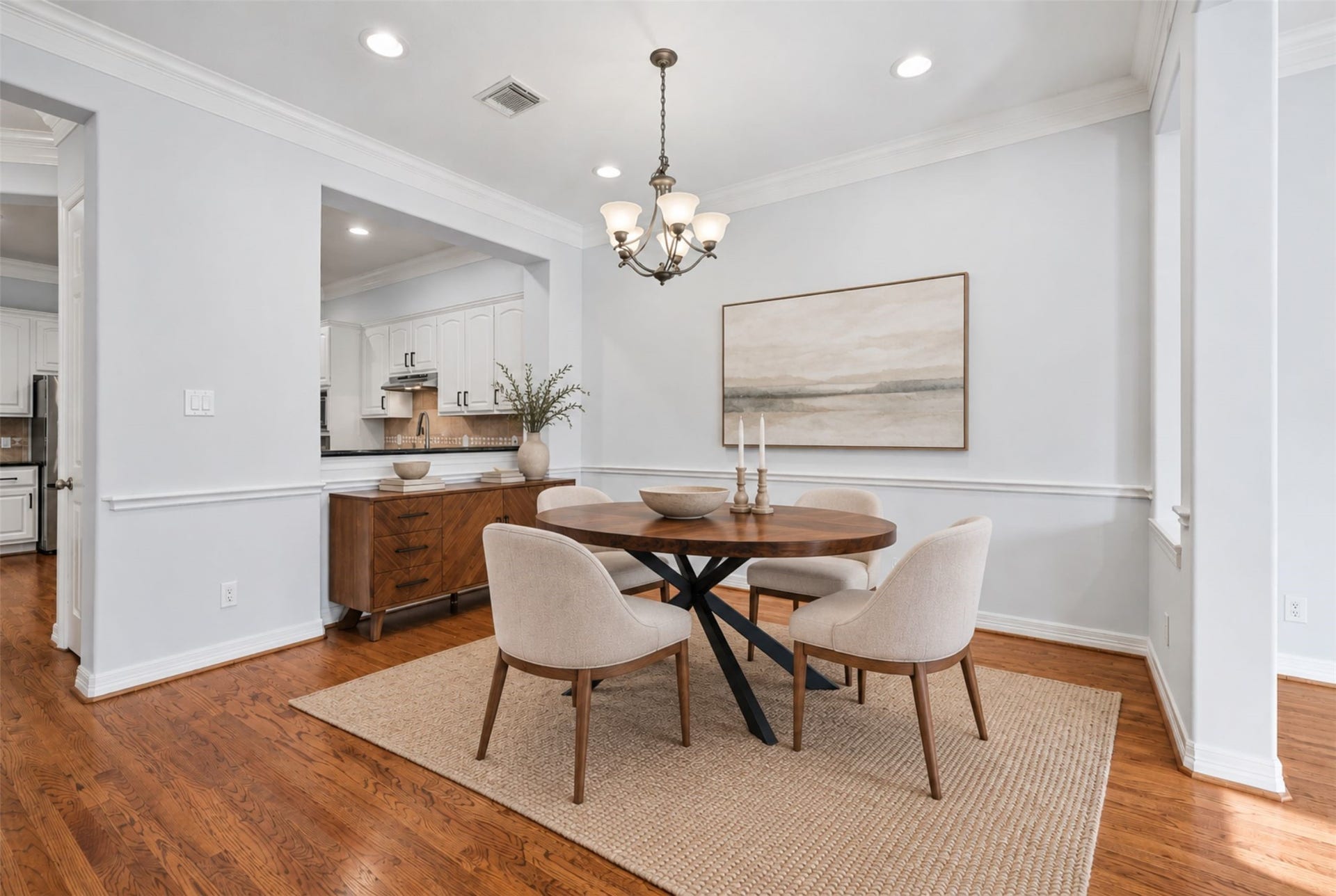 2919 Royal Oaks Crest, Houston, TX 77082 This inviting dining area boasts warm hardwood floors, a chic round table and seamless flow to a modern kitchen, perfect for entertaining. (Virtual Staging)
