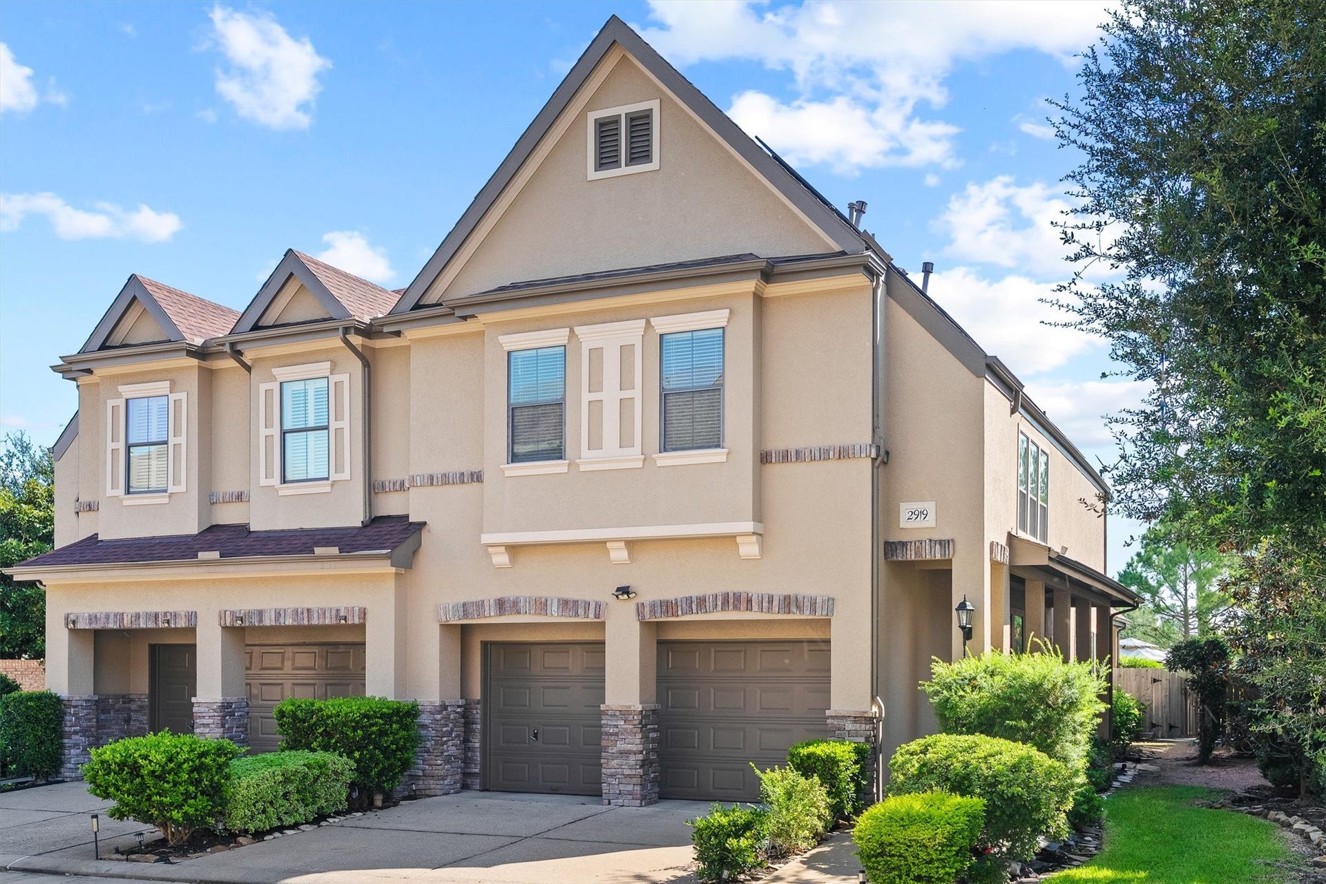 2919 Royal Oaks Crest, Houston, TX 77082 Charming two-story townhouse with a classic facade, featuring a double garage and well-maintained landscaping.
