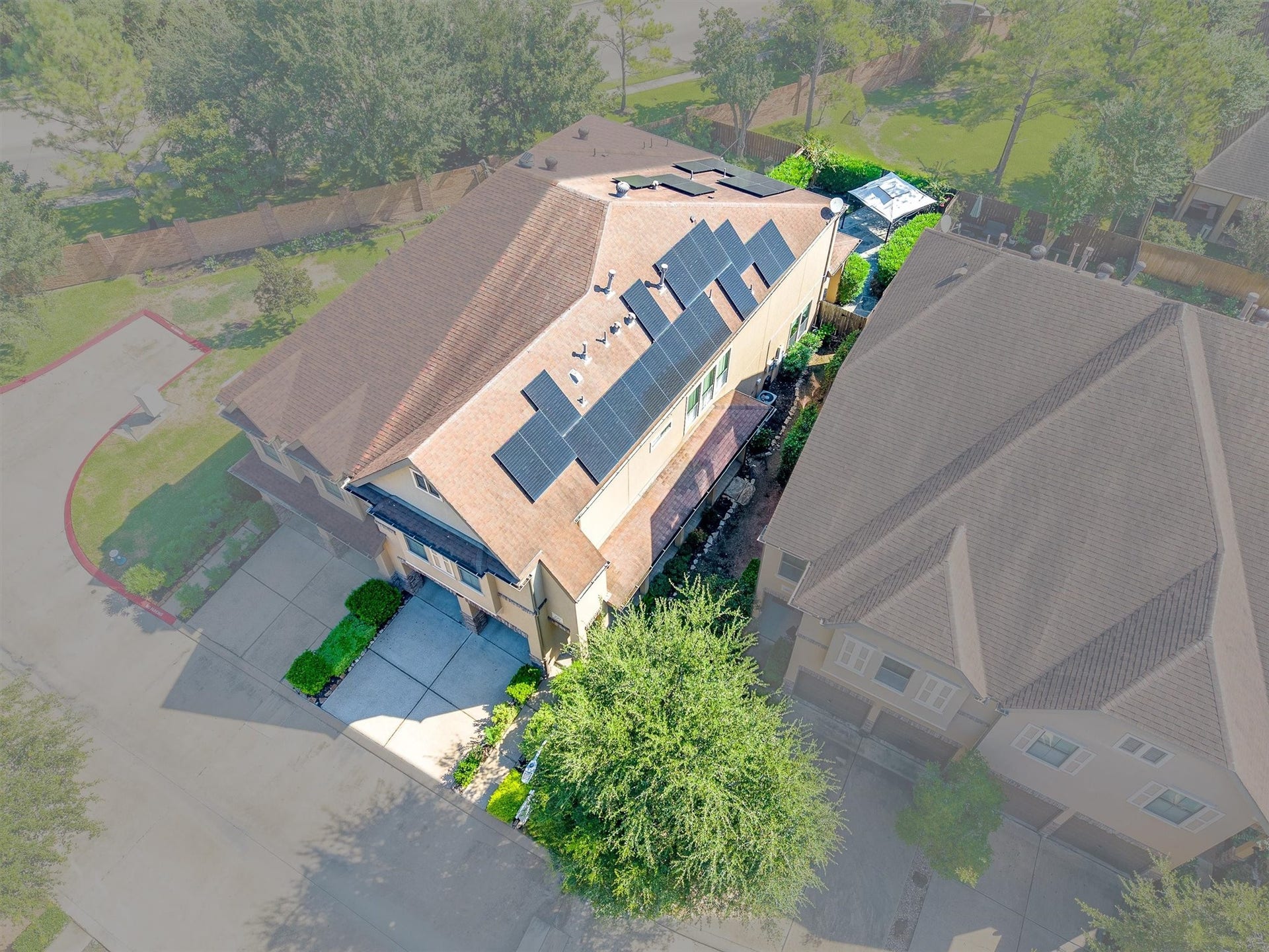 2919 Royal Oaks Crest, Houston, TX 77082 Modern home equipped with solar panels, nestled in a lush, green neighborhood, offering a spacious driveway and well-maintained landscaping.