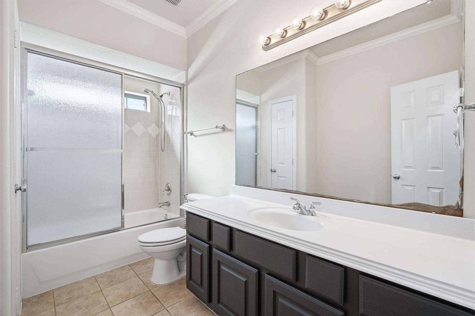 2919 Royal Oaks Crest, Houston, TX 77082 Bright and spacious guest bathroom on the second floor, featuring a sleek vanity with ample storage, a large mirror, and a shower-tub combo with glass doors for a modern touch.