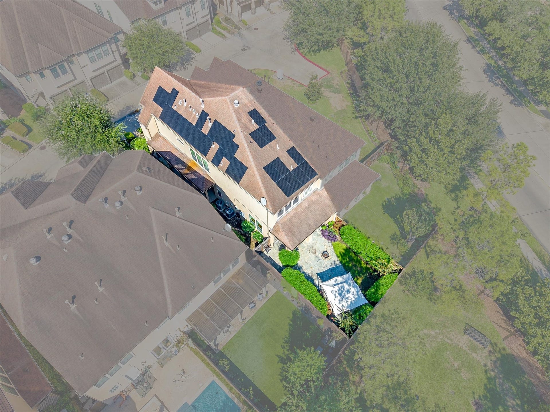 2919 Royal Oaks Crest, Houston, TX 77082 Aerial view of a charming home featuring solar panels and a beautifully landscaped backyard with a cozy patio area.