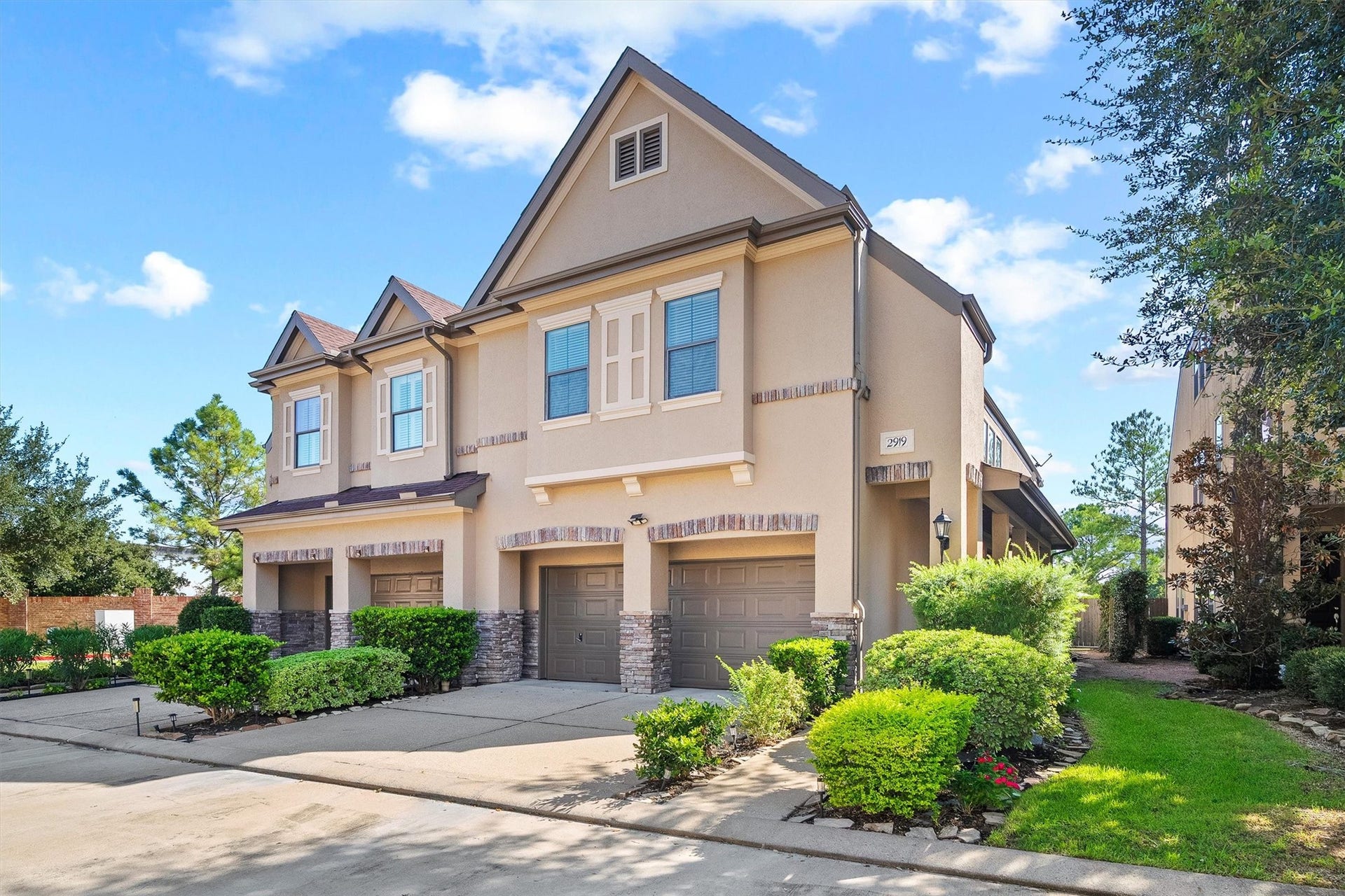 2919 Royal Oaks Crest, Houston, TX 77082 Modern townhouse with a charming facade features a spacious driveway and landscaped front yard, offering excellent curb appeal in a serene neighborhood setting.
