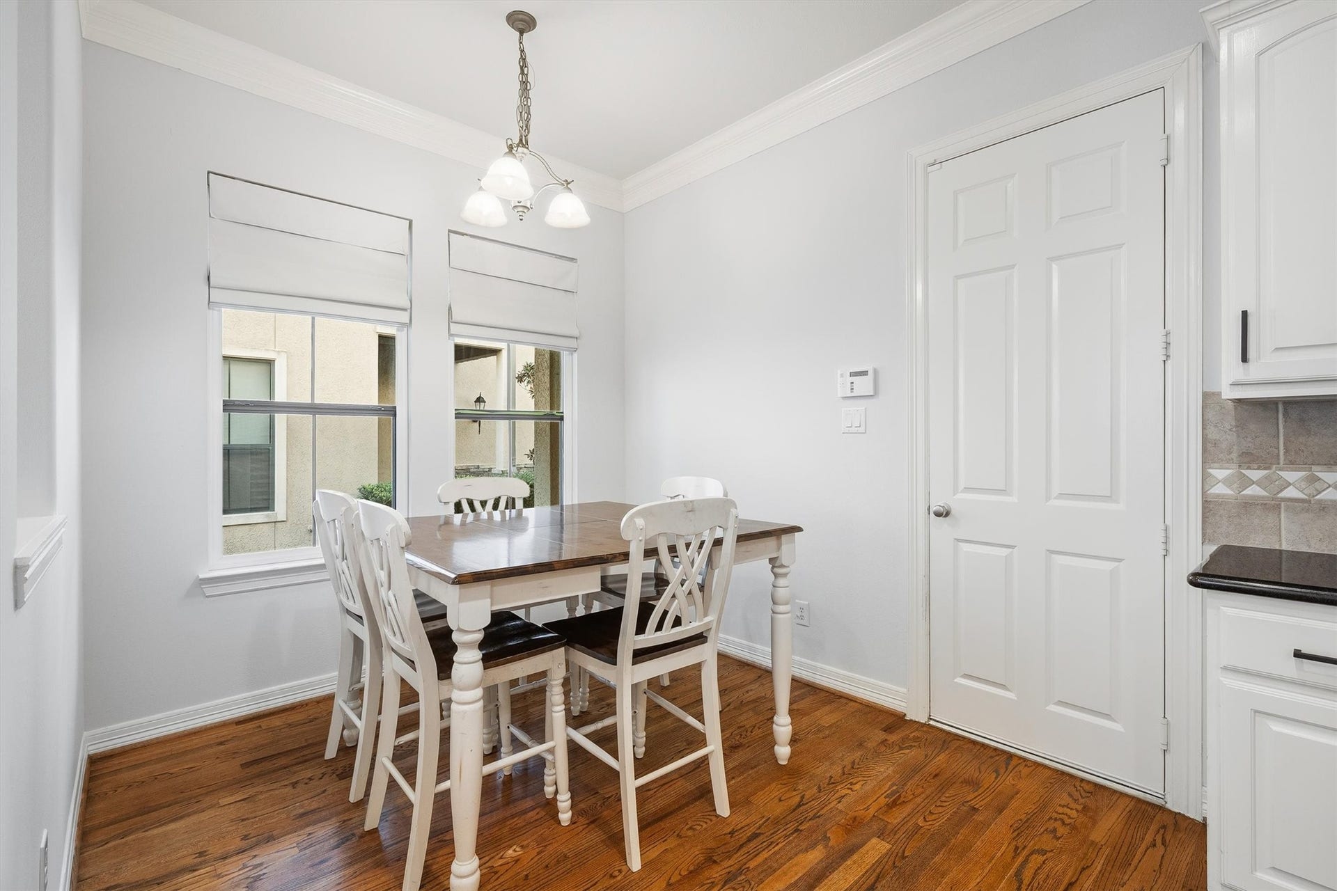 2919 Royal Oaks Crest, Houston, TX 77082 Bright and inviting breakfast nook featuring a classic wooden dining set, complemented by elegant hardwood floors and ample natural light from large windows.
