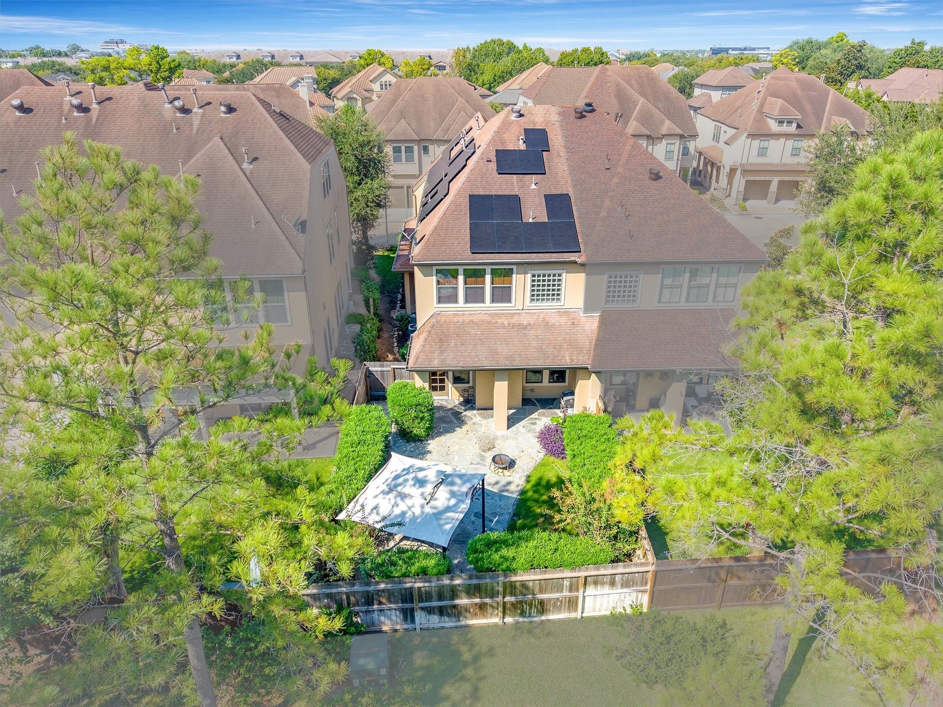 2919 Royal Oaks Crest, Houston, TX 77082 A two-story home with solar panels, nestled in a serene neighborhood, featuring a beautifully landscaped backyard with a cozy patio for outdoor relaxation.