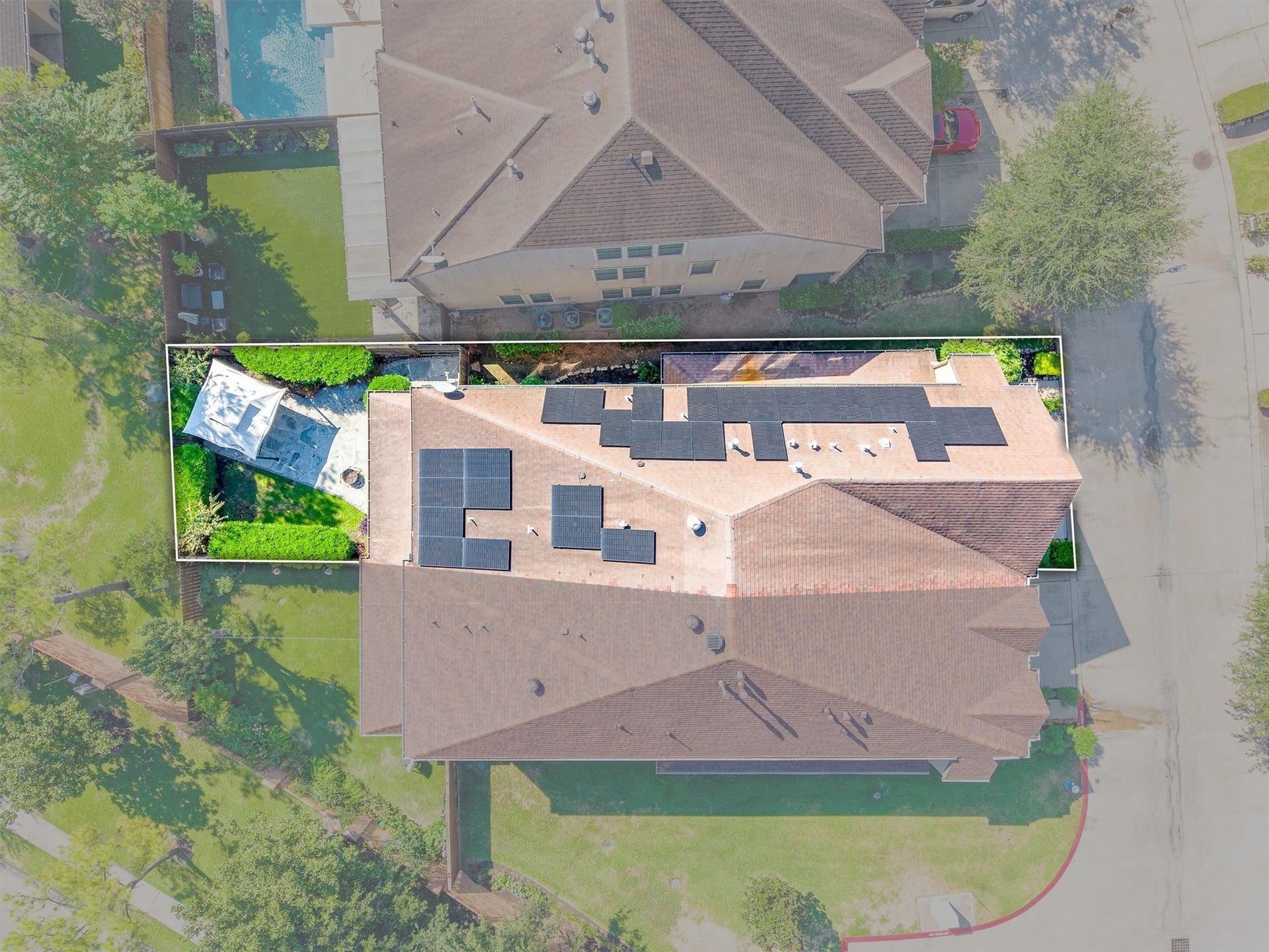 2919 Royal Oaks Crest, Houston, TX 77082 Spacious rooftop with solar panels and a private backyard featuring a patio and lush greenery, perfect for outdoor entertainment and sustainability.
