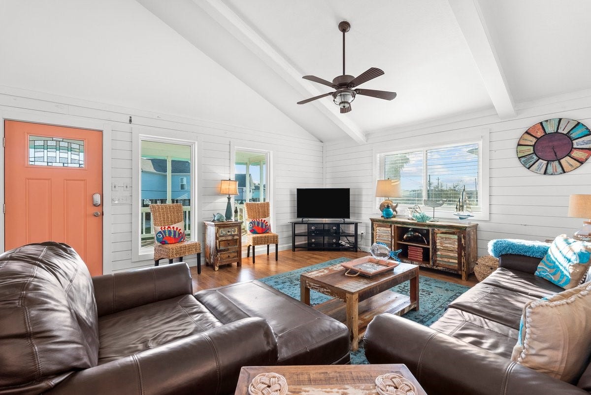 2406 Avenue P, San Leon, TX 77539 This cozy living room features a vaulted ceiling with exposed beams, a warm color palette, and plenty of natural light.