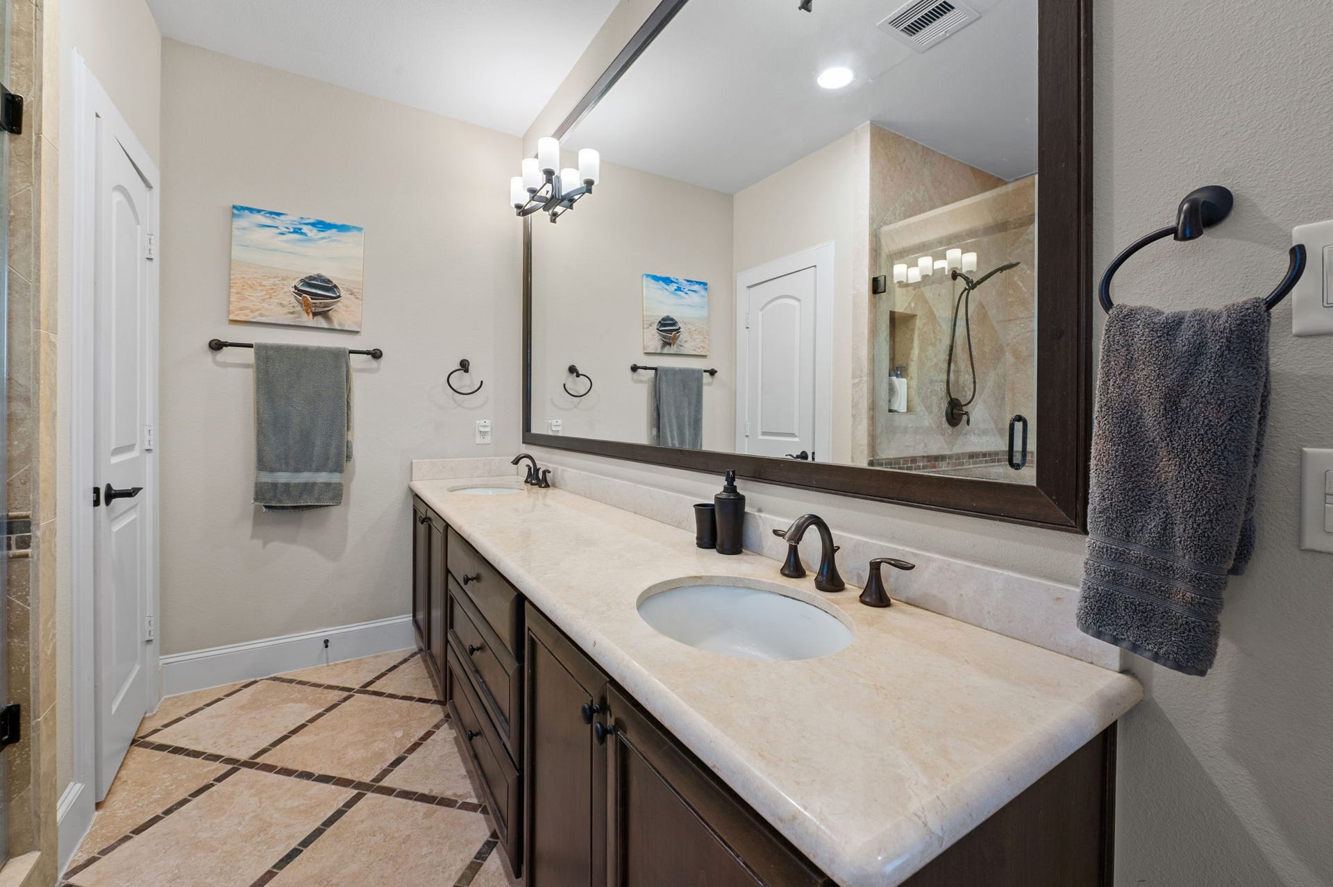 Another view of the primary bath with double sinks and a huge mirror and counter top space.