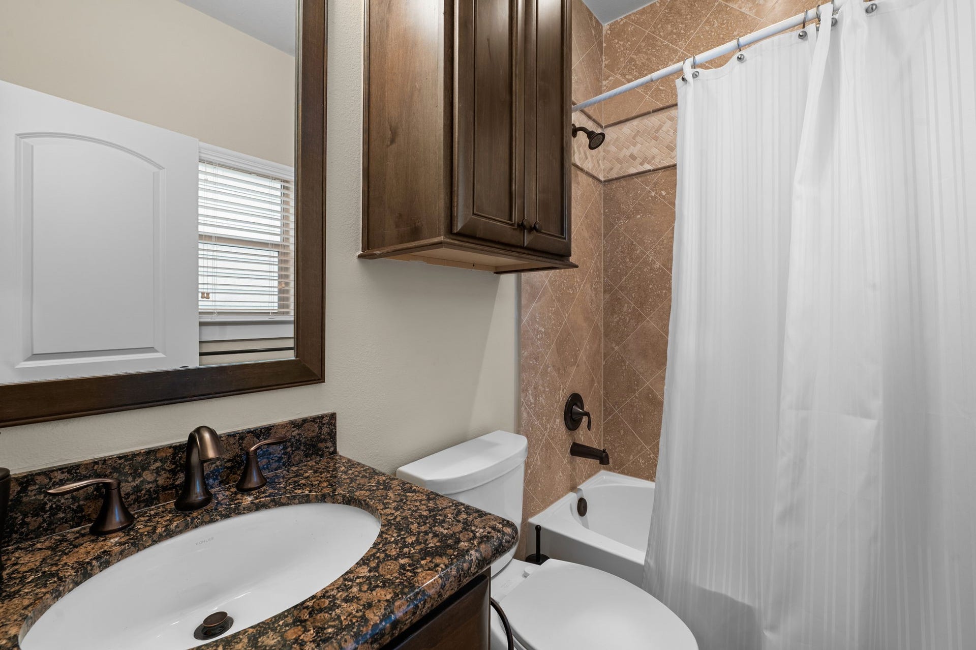 Bedroom 3 is located on the first floor and boasts a walk in closet, ensuite bathroom, and wood floors.
