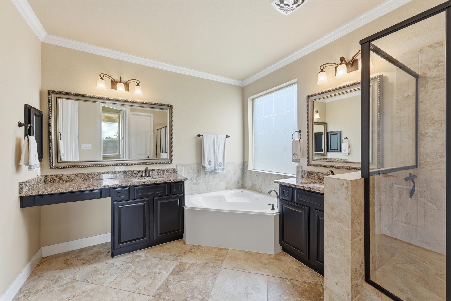 Primary bathroom with double sinks, jetted tub, separate shower, and large walk-in closet.