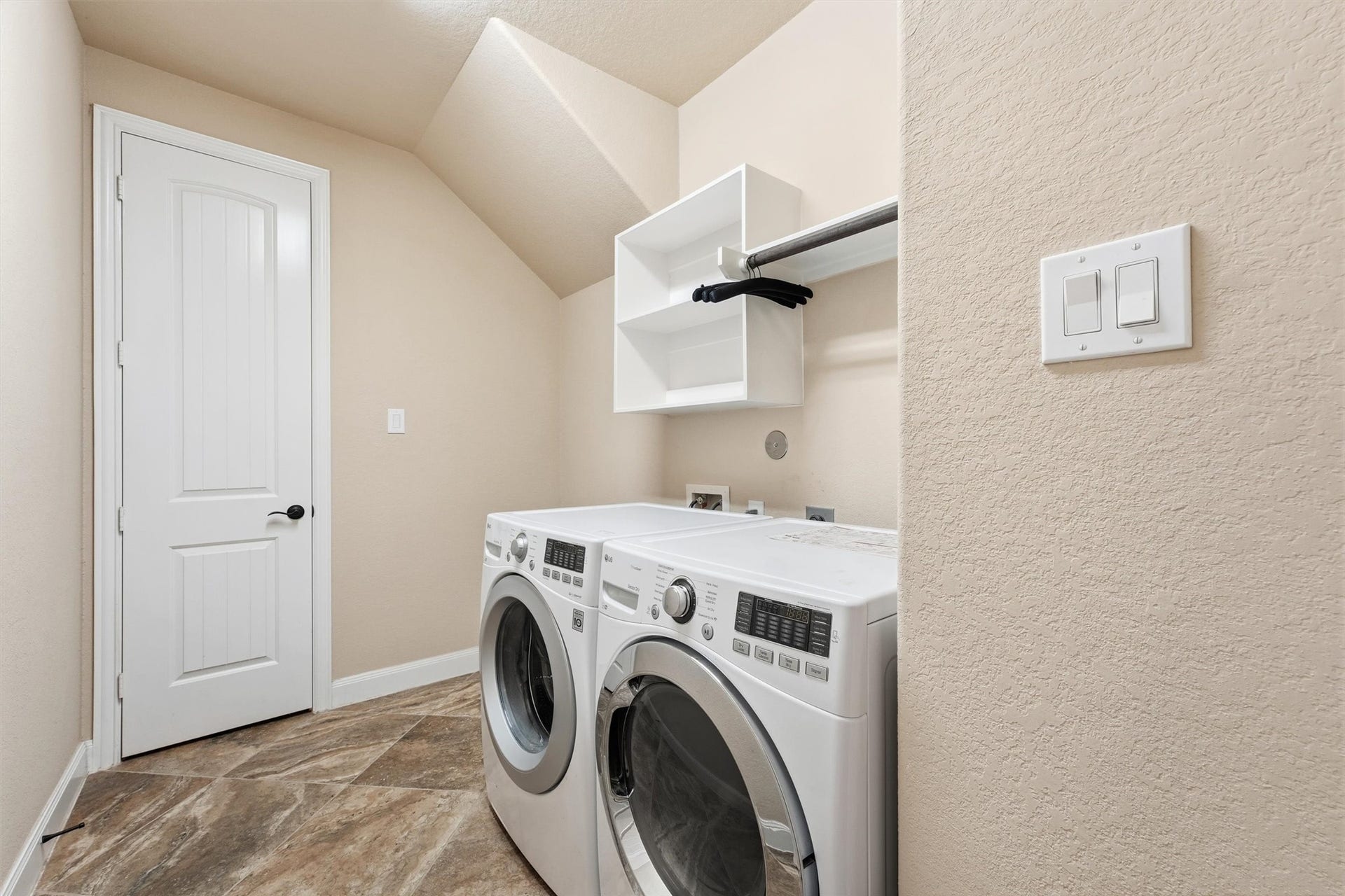 Laundry room with space for a fridge.