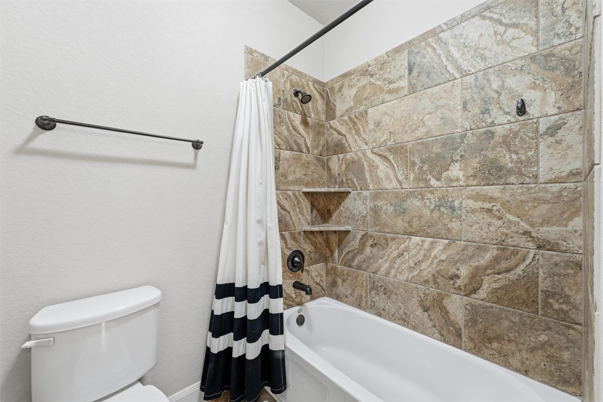 Secondary bathroom with double sinks and tub w/ shower.
