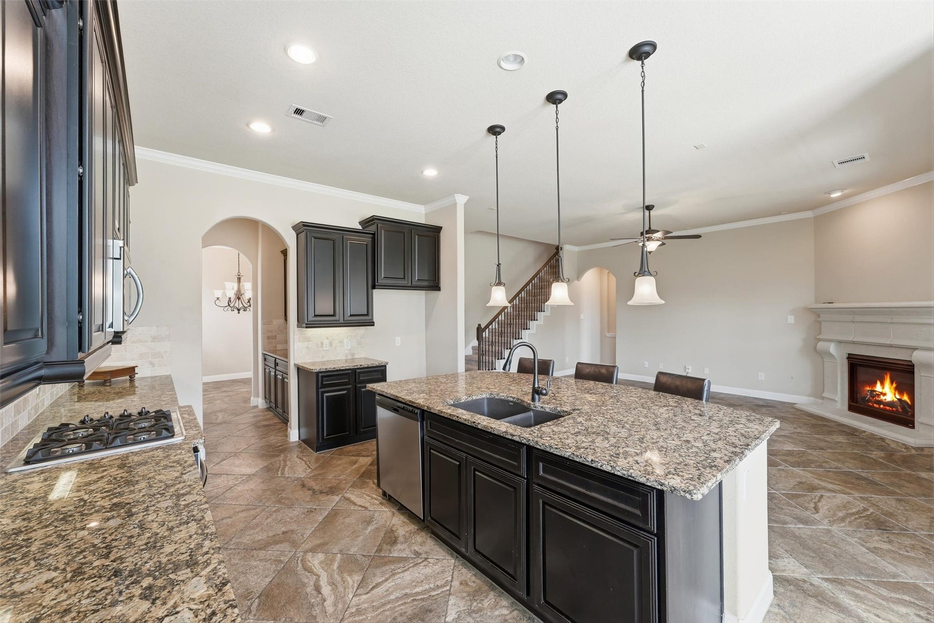 Island kitchen with breakfast bar, granite counters, and stainless steel appliances - all overlooking the living room with views to the backyard retreat. *fireplace virtually lit*
