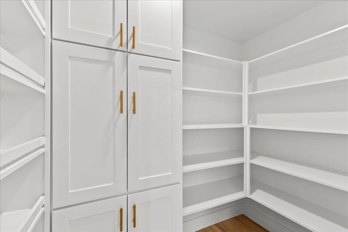 8323 Observatory Street, #A/B, Houston, TX 77088 Unit A - The spacious pantry features custom-built cabinetry, dedicated shelving, and a convenient spice rack, providing exceptional organization and storage while adding a touch of luxury and functionality to the kitchen.