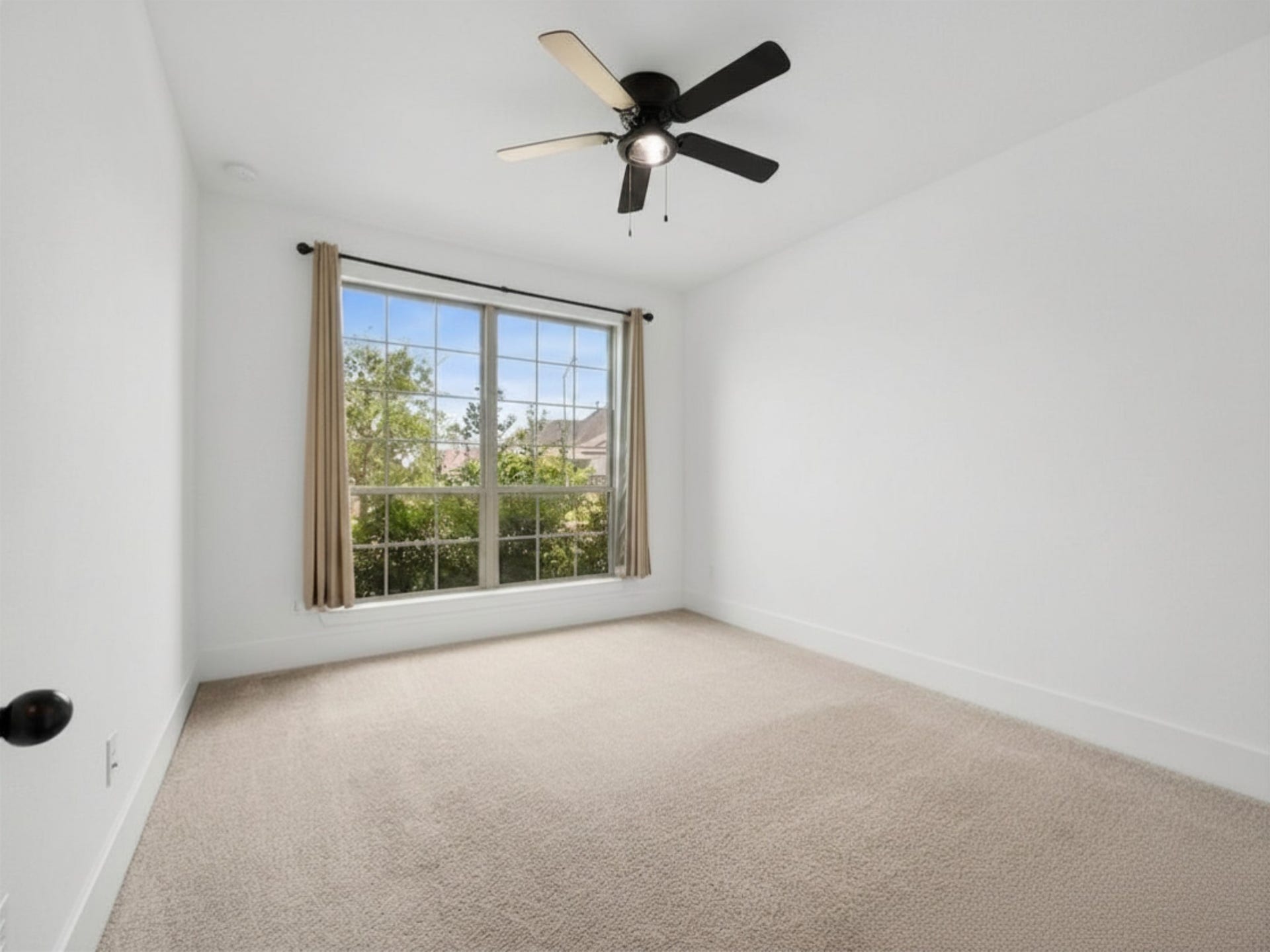 1911 Golden Leaf Drive, Missouri City, TX 77459 Bright secondary bedroom downstairs with ceiling fan and large window.
