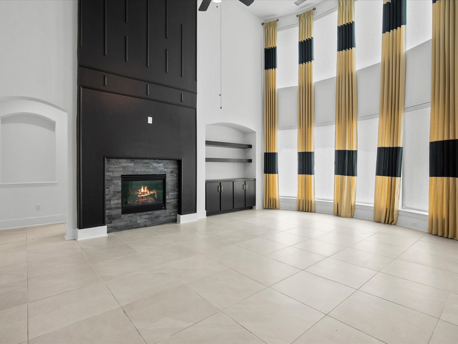 1911 Golden Leaf Drive, Missouri City, TX 77459 Cozy fireplace framed by a bold black accent wall with built-in shelving.