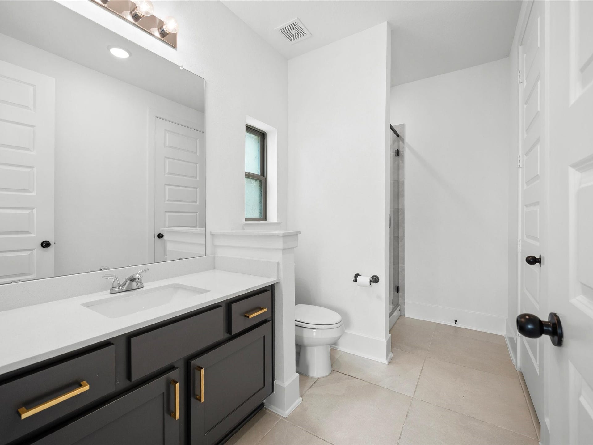 1911 Golden Leaf Drive, Missouri City, TX 77459 Guest suite walk-in shower with dark accent cabinetry.