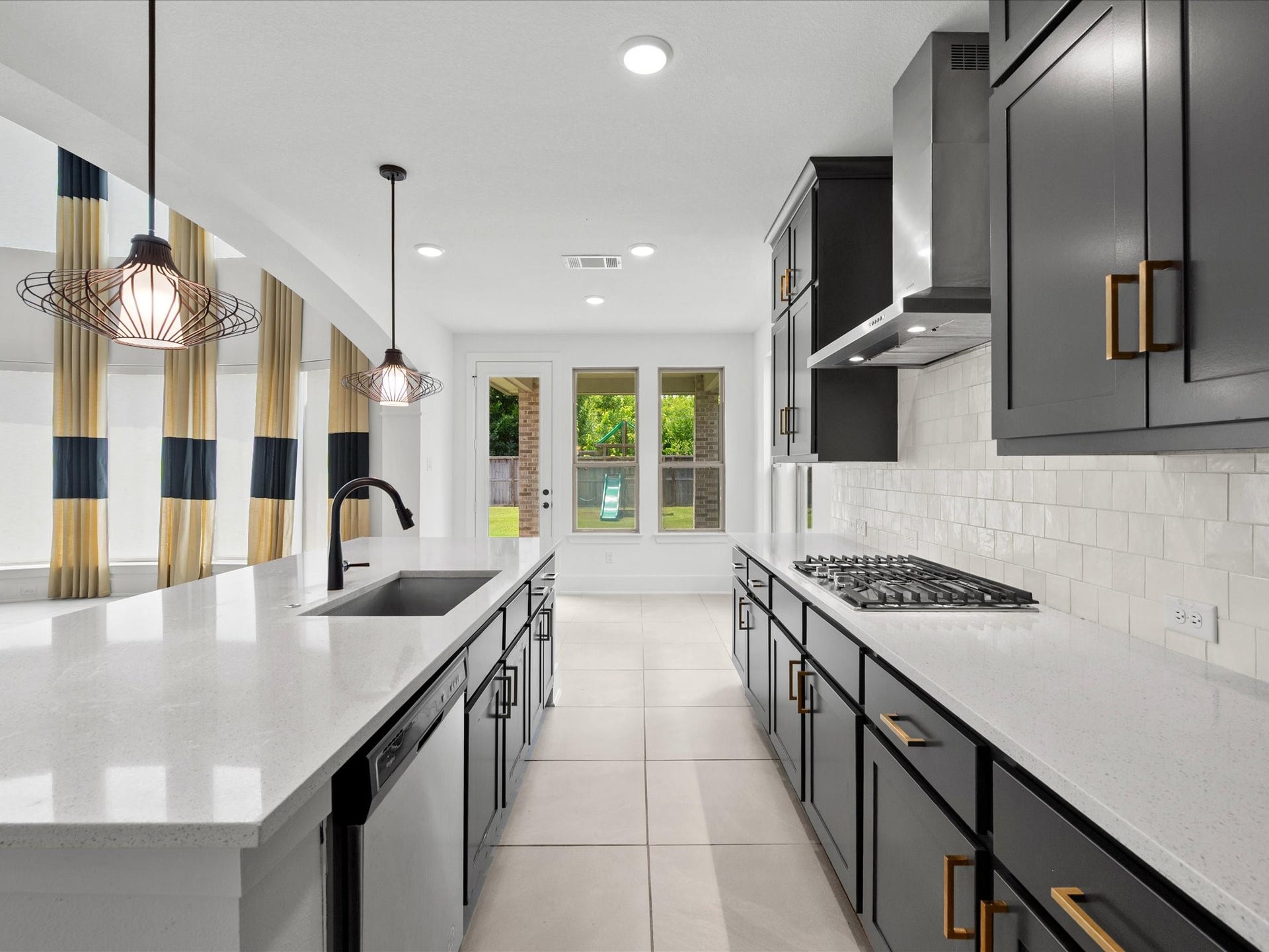 1911 Golden Leaf Drive, Missouri City, TX 77459 Open-concept kitchen with glowing Spanish ceramic tile backsplash, flowing into the breakfast and family areas.