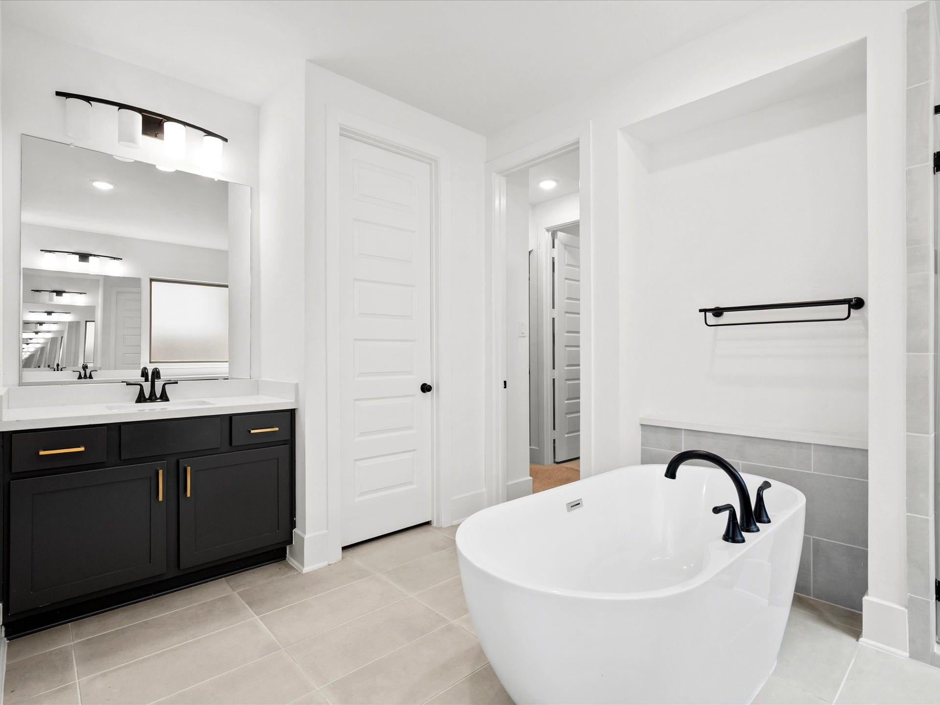1911 Golden Leaf Drive, Missouri City, TX 77459 Primary bath dual vanities with dark cabinetry and modern fixtures.