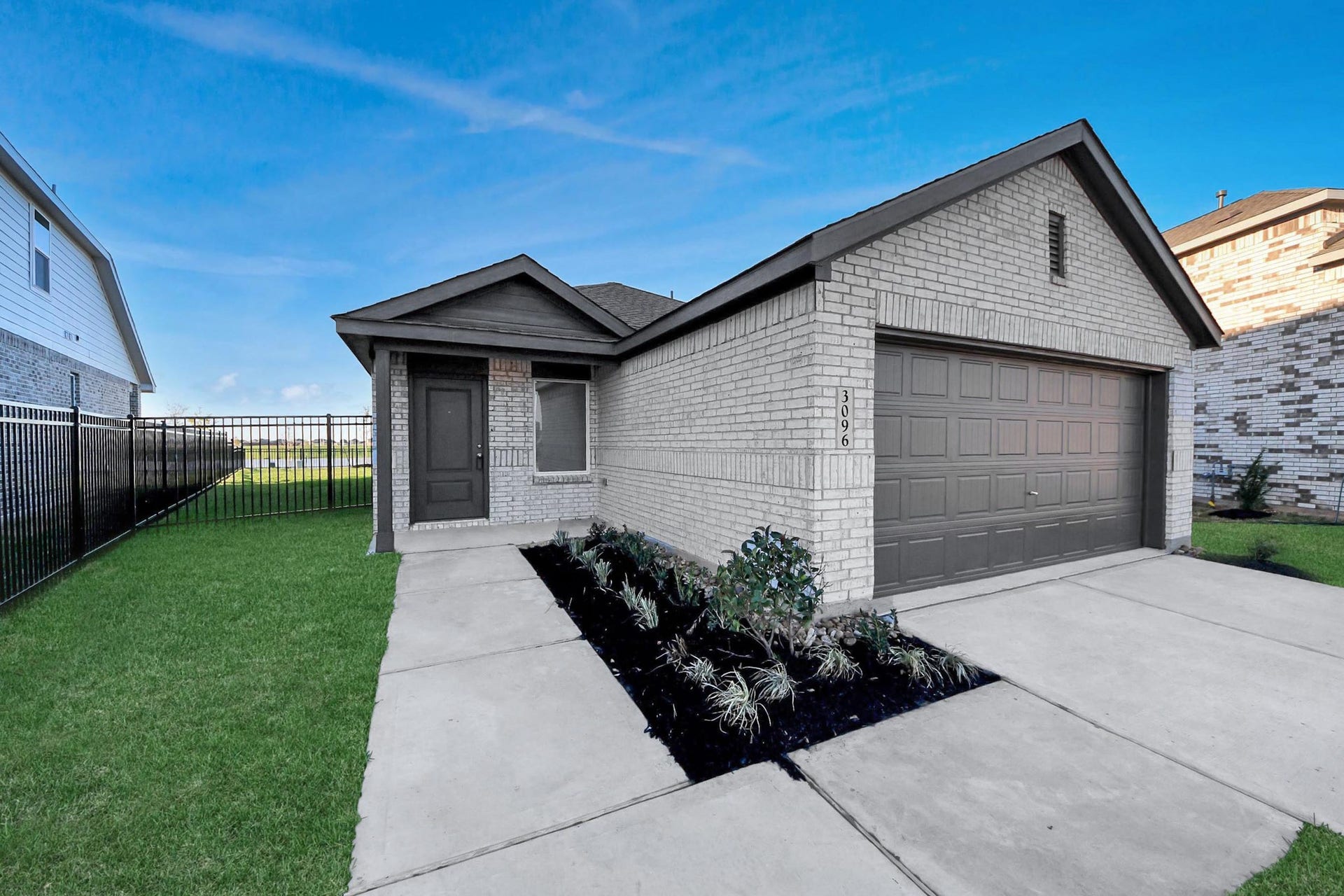 3096 Sunset Glory Drive, Katy, TX 77493 Modern single-story home with a clean brick exterior, attached two-car garage, and neatly landscaped front yard. Ideal for easy maintenance and convenience.