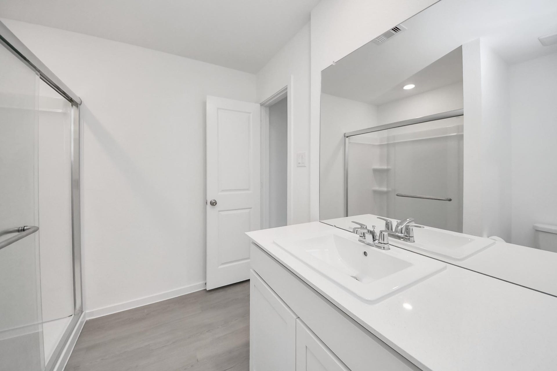 3096 Sunset Glory Drive, Katy, TX 77493 This bathroom features a modern, clean design with a double sink vanity, a large mirror, and a spacious glass-enclosed shower. The neutral color palette and ample lighting create a bright, welcoming atmosphere.