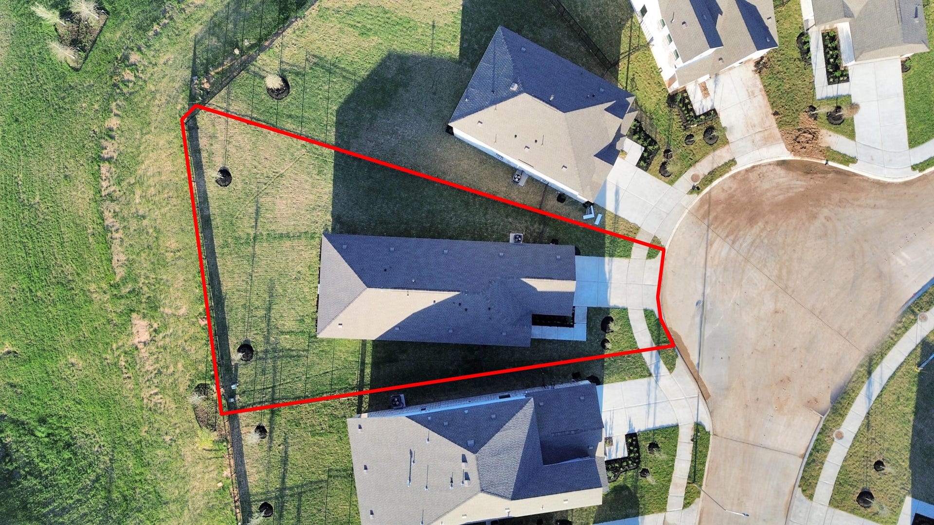3096 Sunset Glory Drive, Katy, TX 77493 This aerial photo shows a house situated on a pie-shaped lot at the end of a cul-de-sac. The property has a spacious backyard, outlined in red, with a driveway leading to the garage. The surrounding area features neatly maintained lawns and neighboring houses.