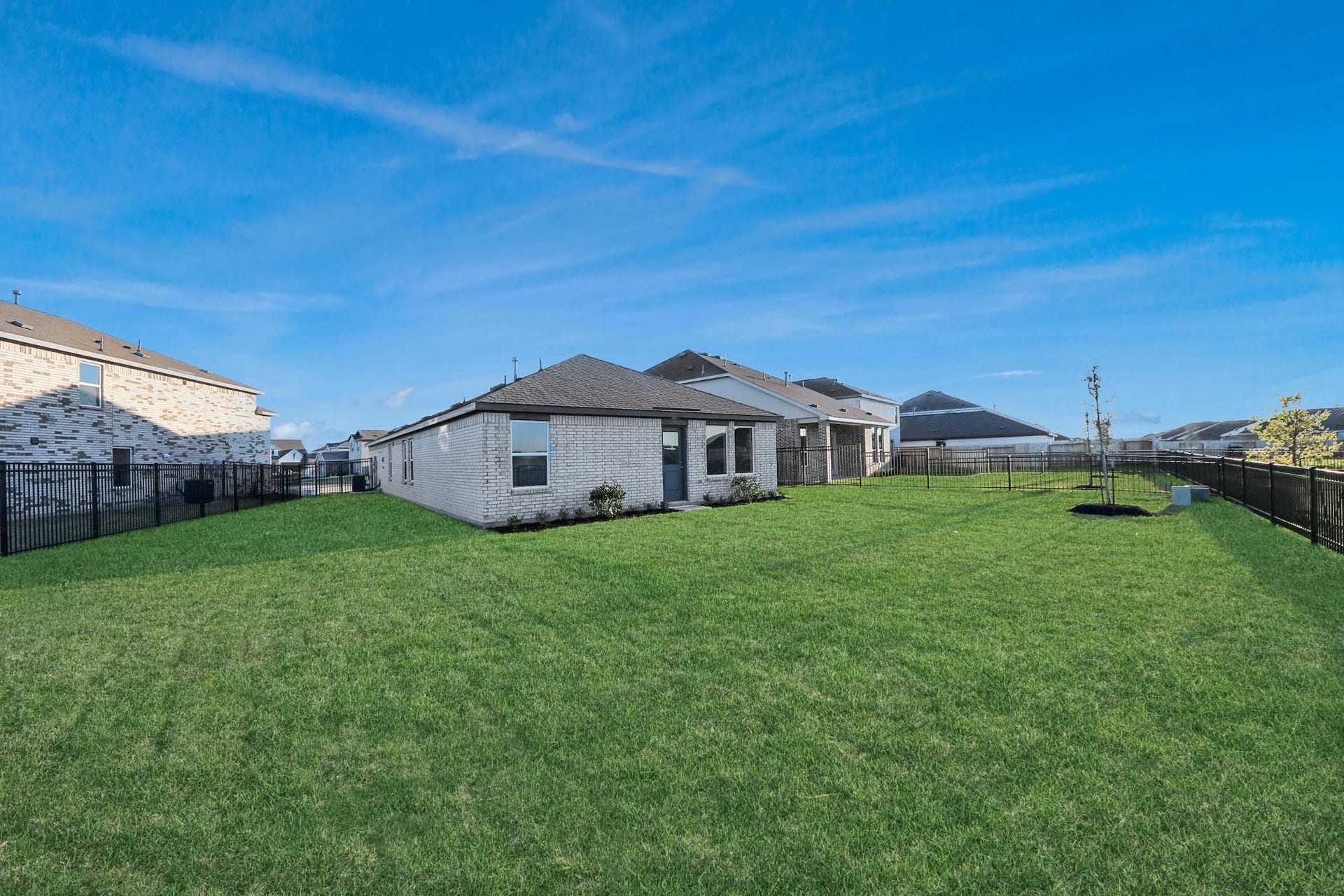 3096 Sunset Glory Drive, Katy, TX 77493 Spacious backyard with well-maintained lawn and modern fencing, perfect for outdoor activities. The home features a brick exterior and large windows, enhancing natural light. Ideal for families seeking a blend of comfort and privacy.
