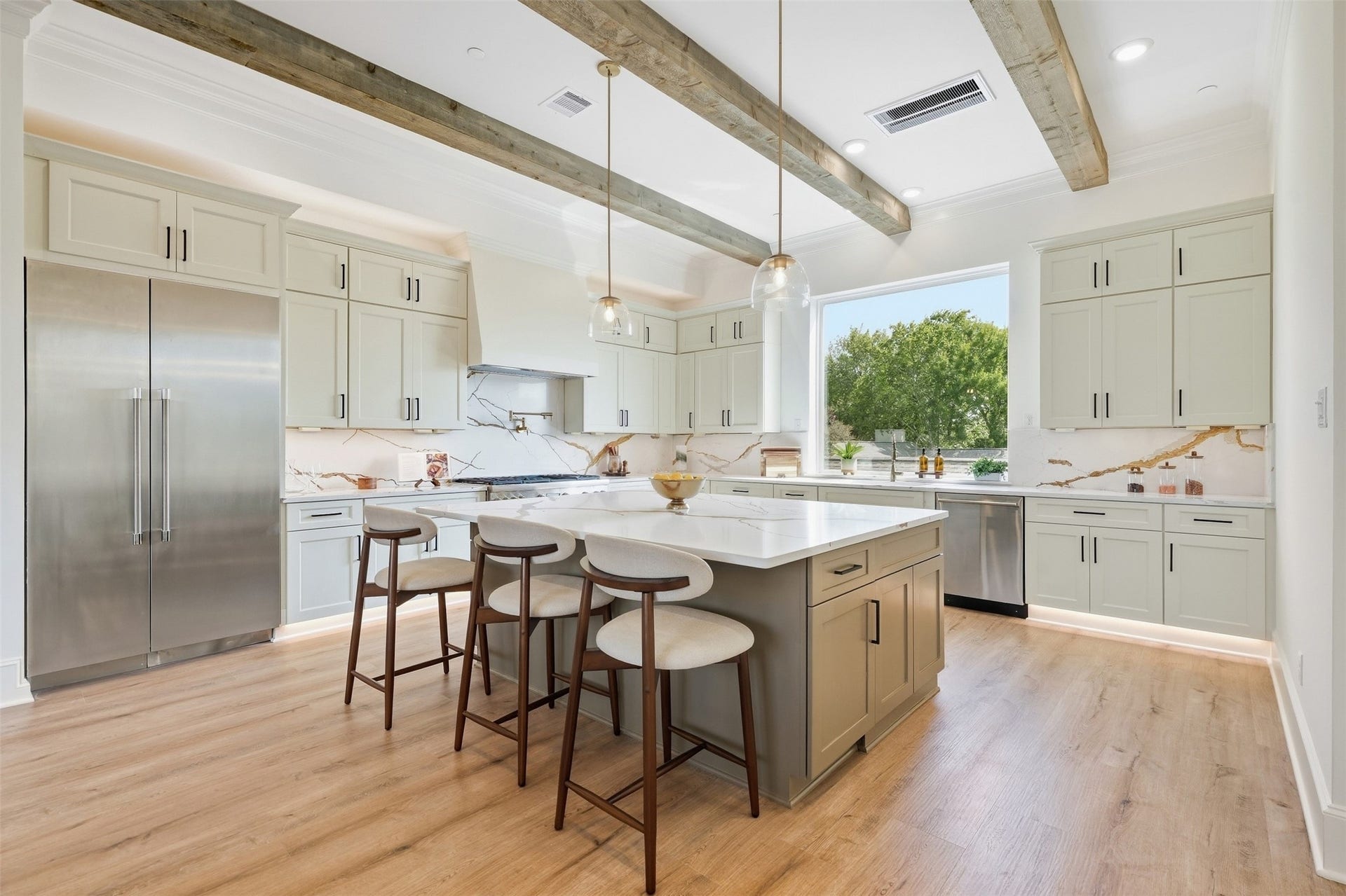 2111 Nantucket Drive, #C, Houston, TX 77057 The chef's kitchen pairs an oversized island with custom cabinetry, designer lighting, and rich cedar beams for an elevated yet welcoming feel.