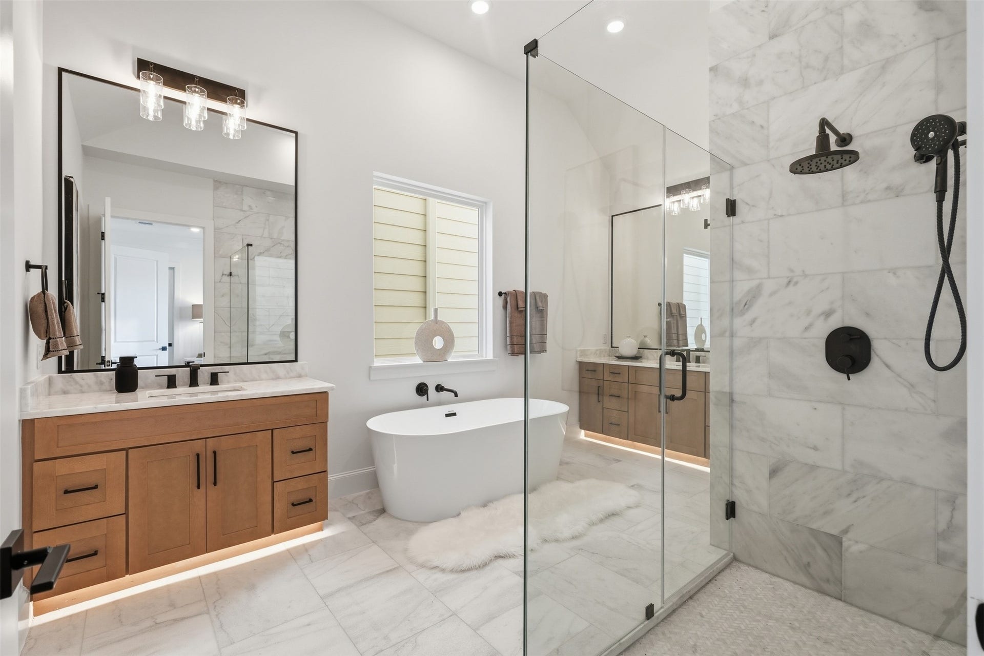2111 Nantucket Drive, #C, Houston, TX 77057 The spa-inspired primary bath features a freestanding soaking tub, oversized glass-enclosed shower, dual vanities, and beautiful marble finishes.
