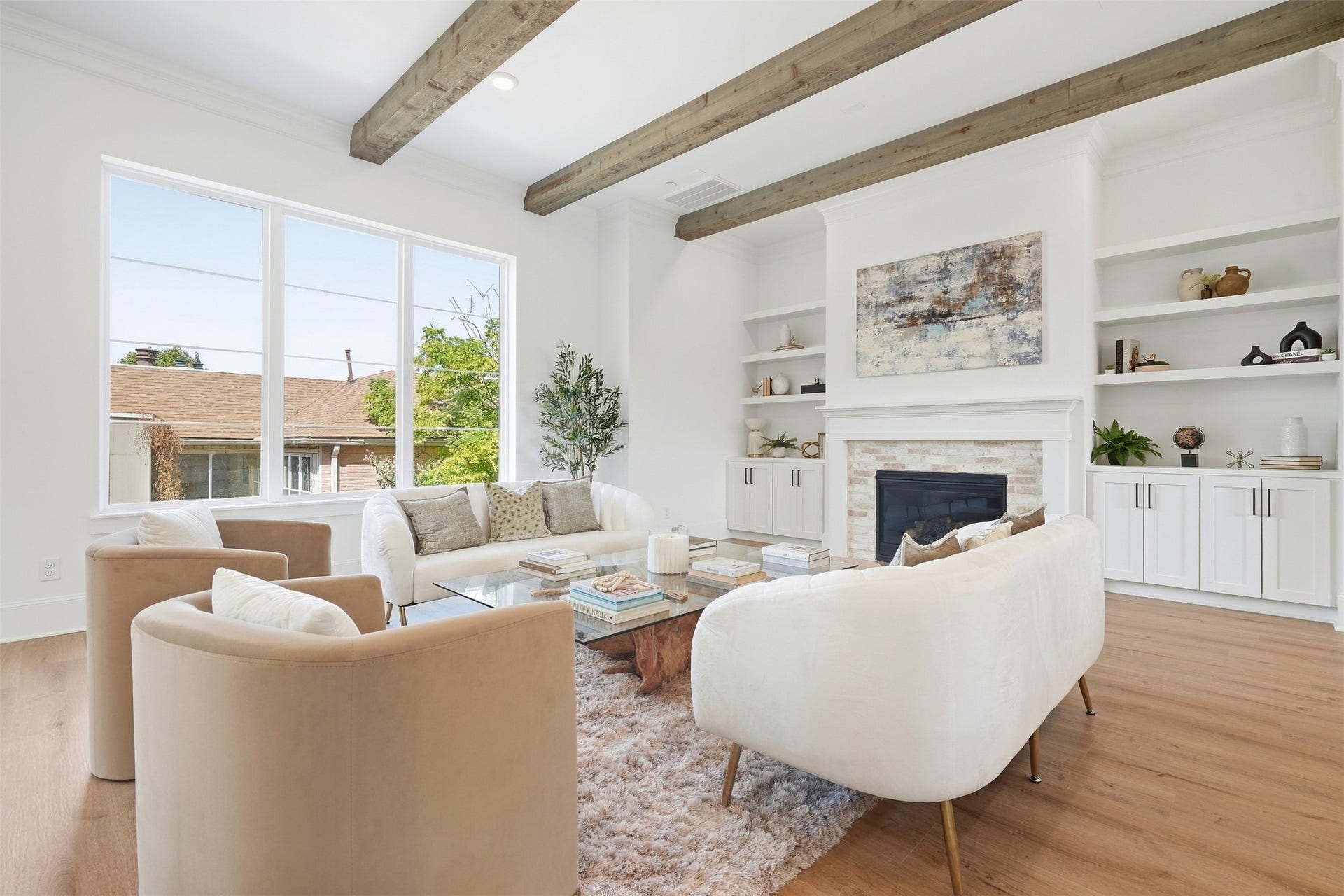 2111 Nantucket Drive, #C, Houston, TX 77057 Spacious living area with soaring ceilings, exposed wood beams, custom built-ins, fireplace, and oversized windows that fill the space with natural light.
